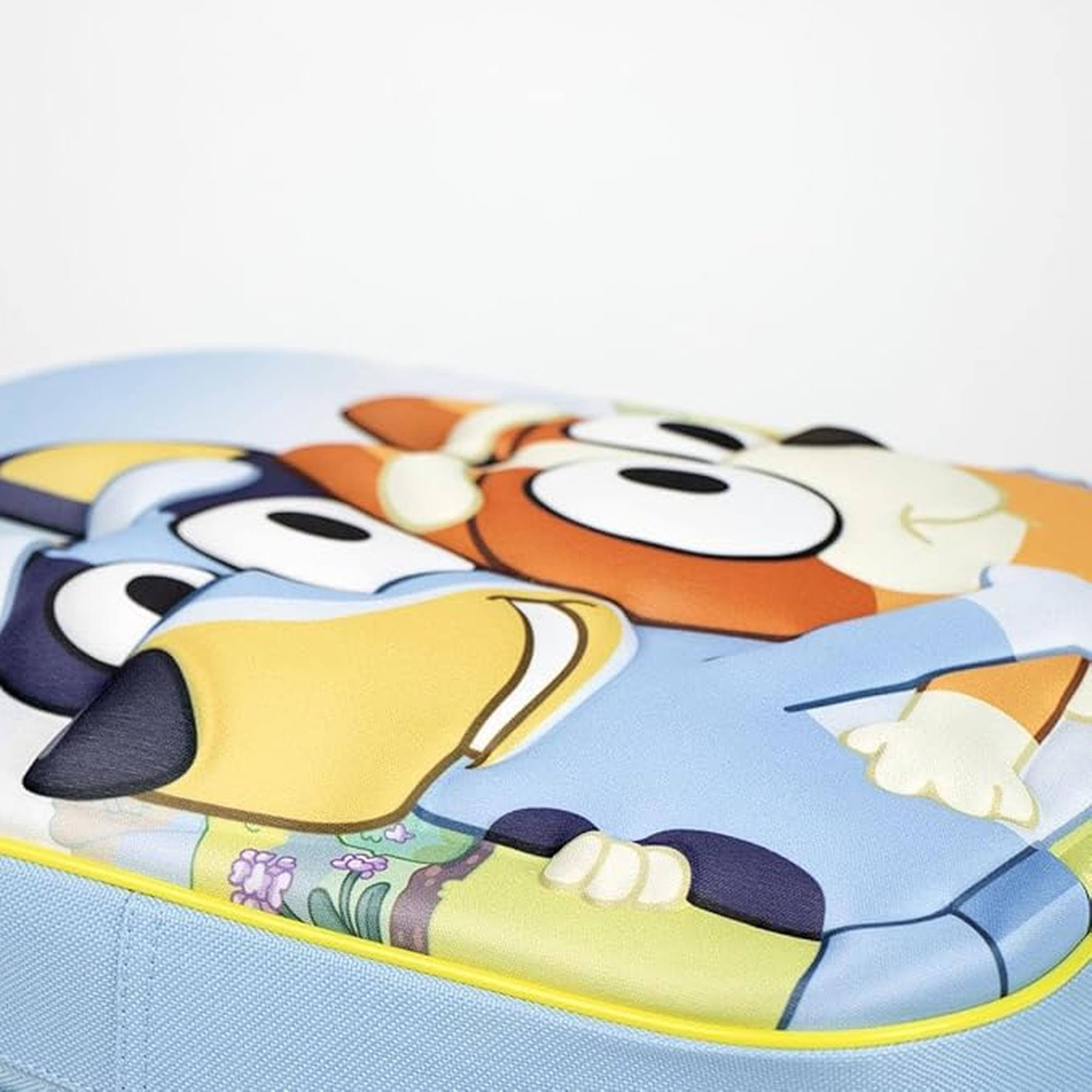 Primer plano de Bluey y Bingo abrazándose. Bluey es azul, Bingo es naranja. Fondo azul claro.