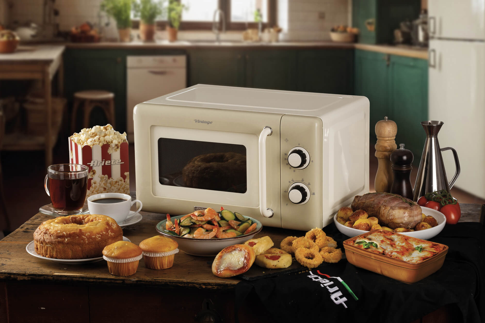 Beżowa kuchenka mikrofalowa w stylu vintage na stole z jedzeniem. Filiżanka, popcorn, ciasto, babeczki, krewetki, makaron i inne.