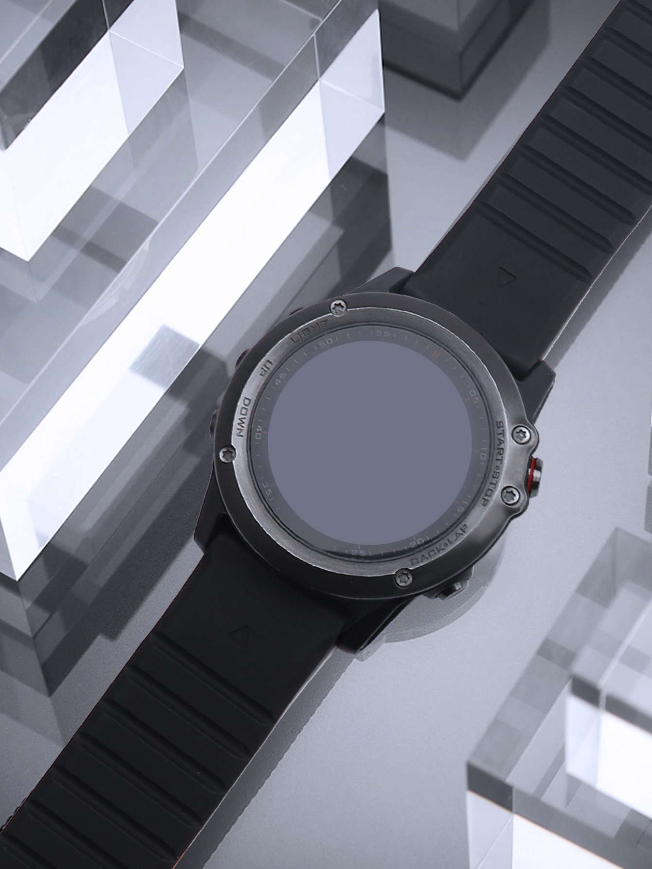 Eine Smartwatch mit schwarzem Armband auf einer Glasoberfläche.