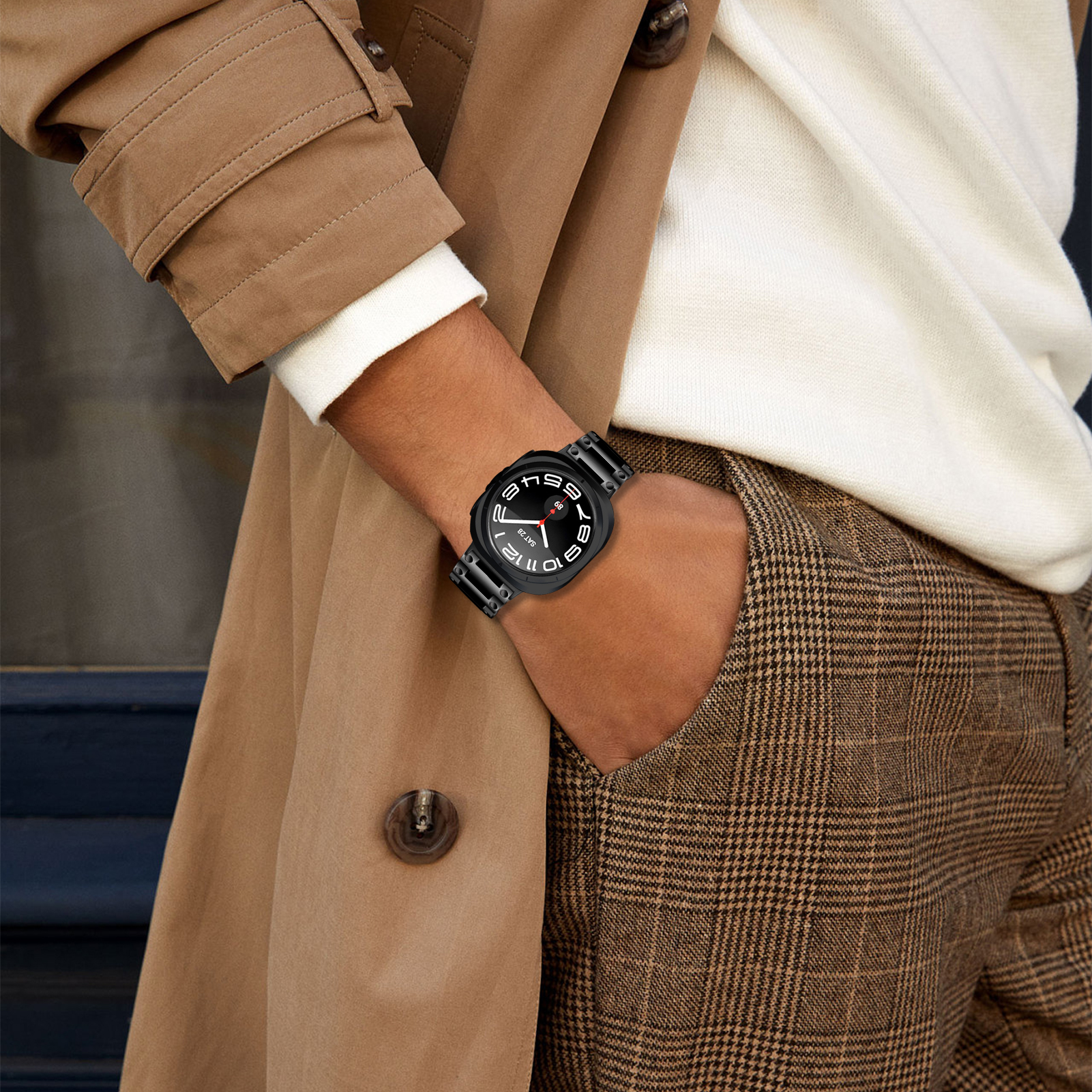 Ein Mann trägt eine Uhr an seinem Handgelenk. Die Uhr hat ein Metallarmband.