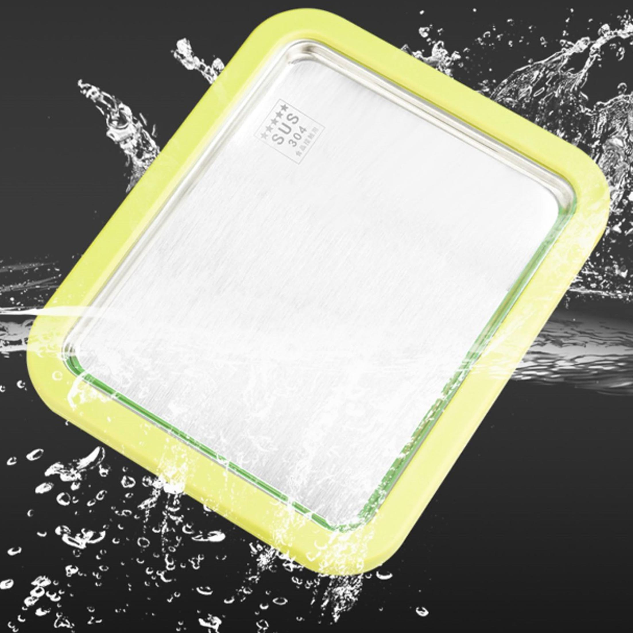Ein Edelstahl-Tablett mit gelbem Rahmen, umgeben von Wassertropfen. Der Hintergrund ist schwarz.