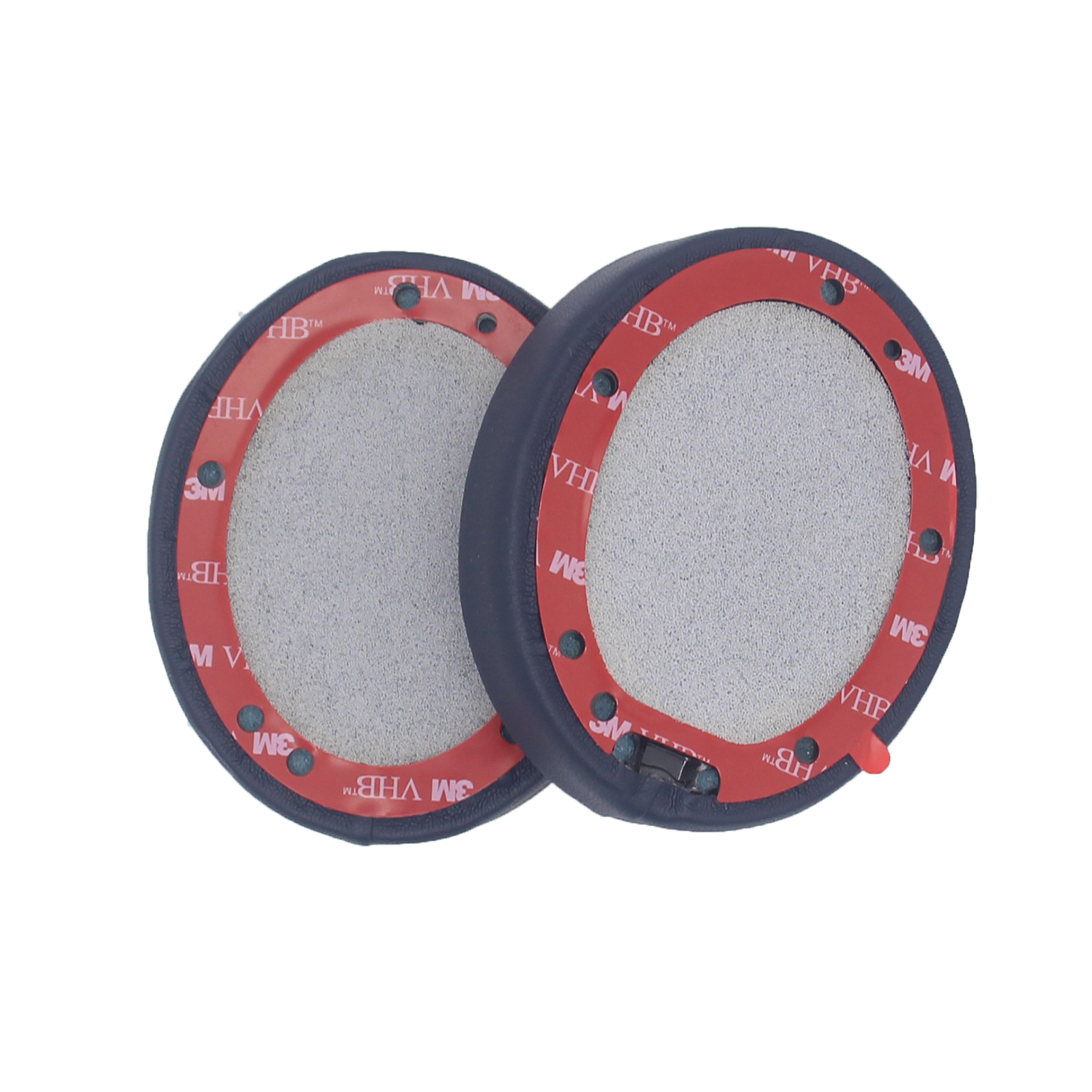 Dwie niebieskie poduszki nauszne do słuchawek z czerwoną taśmą klejącą w środku.