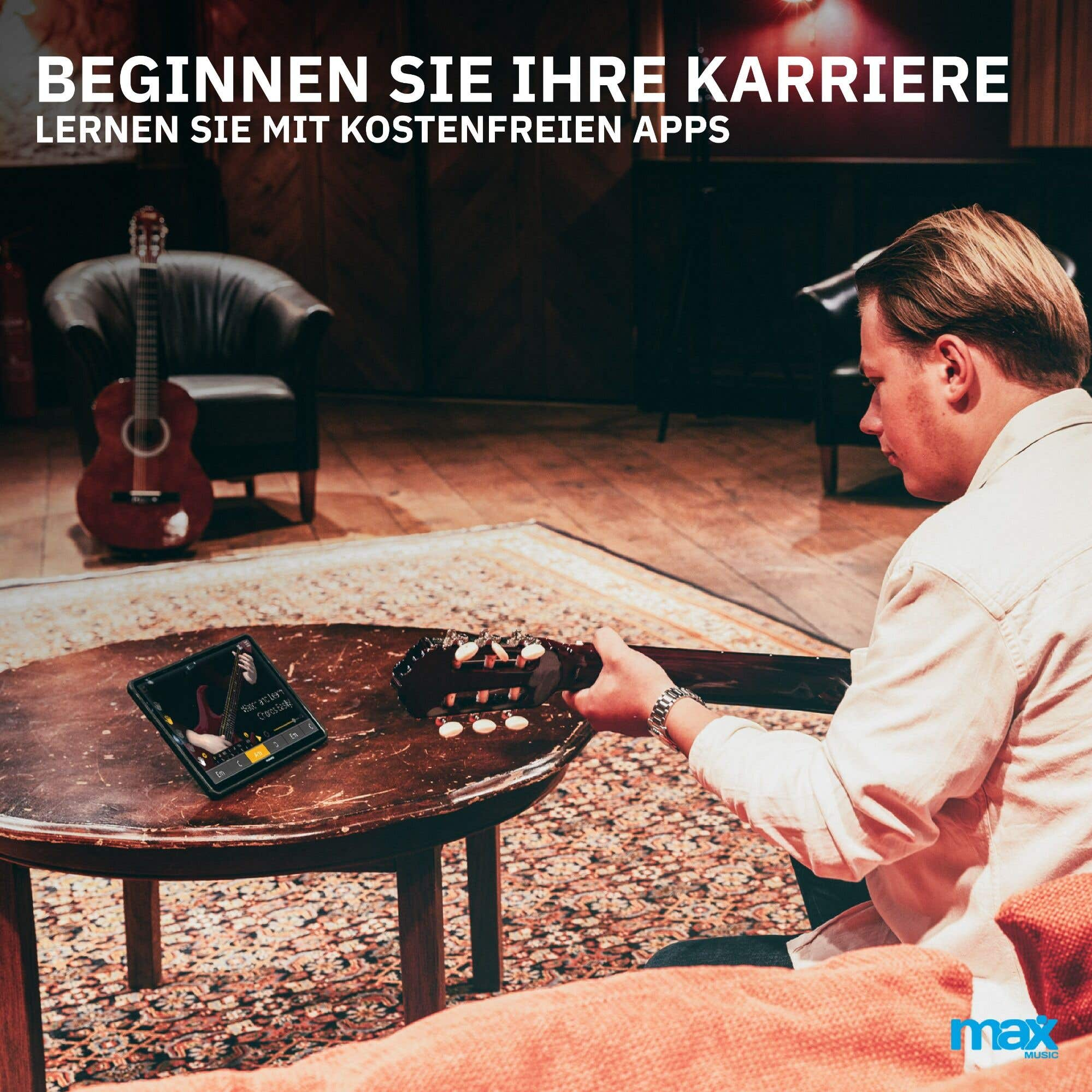 Ein Mann spielt Gitarre, mit einem Tablet, das eine Musik-App zeigt, in einem Raum mit Sofa und Stuhl.
