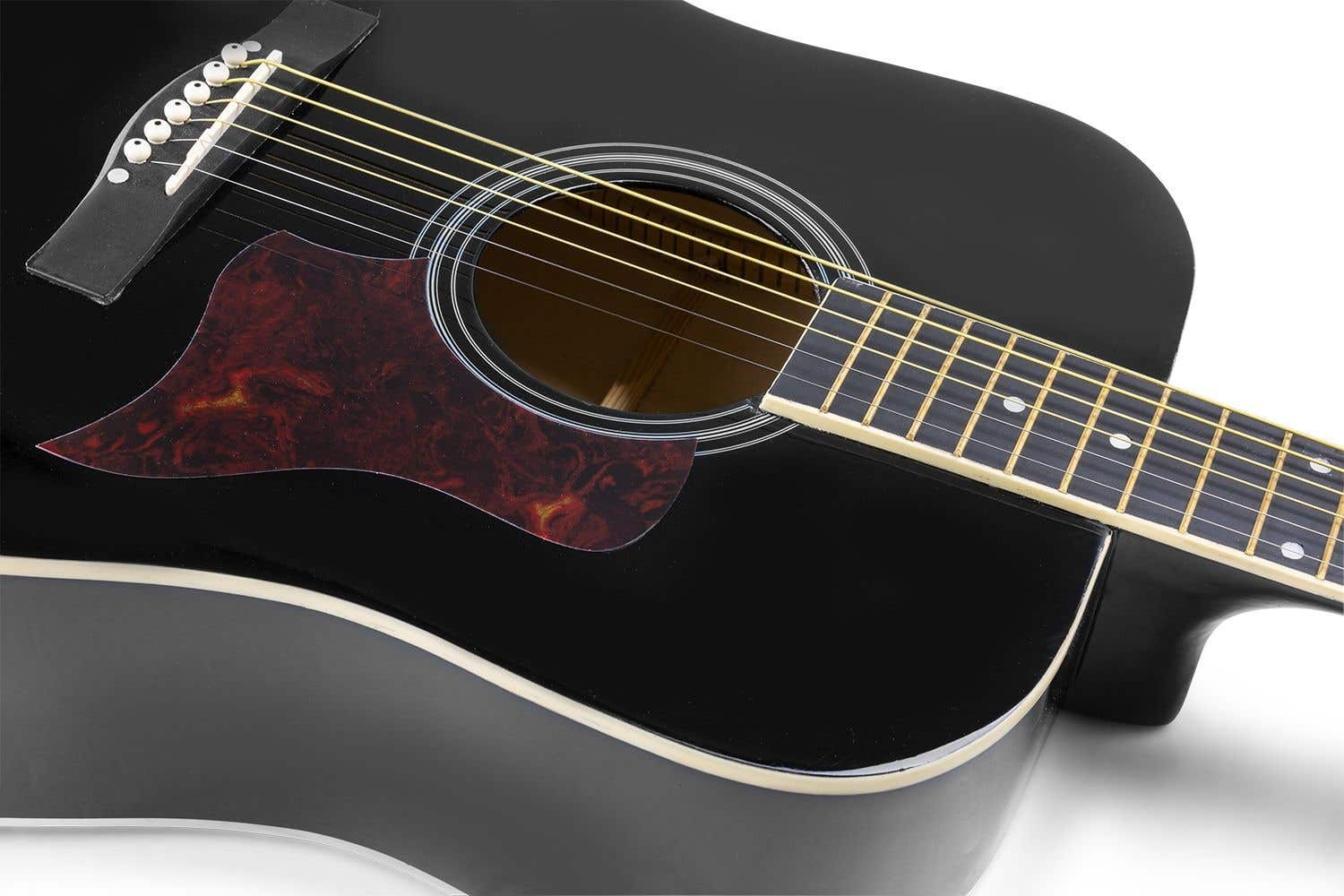 Zwarte akoestische gitaar. Donkerrode slagplaat. Snaren zichtbaar. Op een wit oppervlak. Close-up.