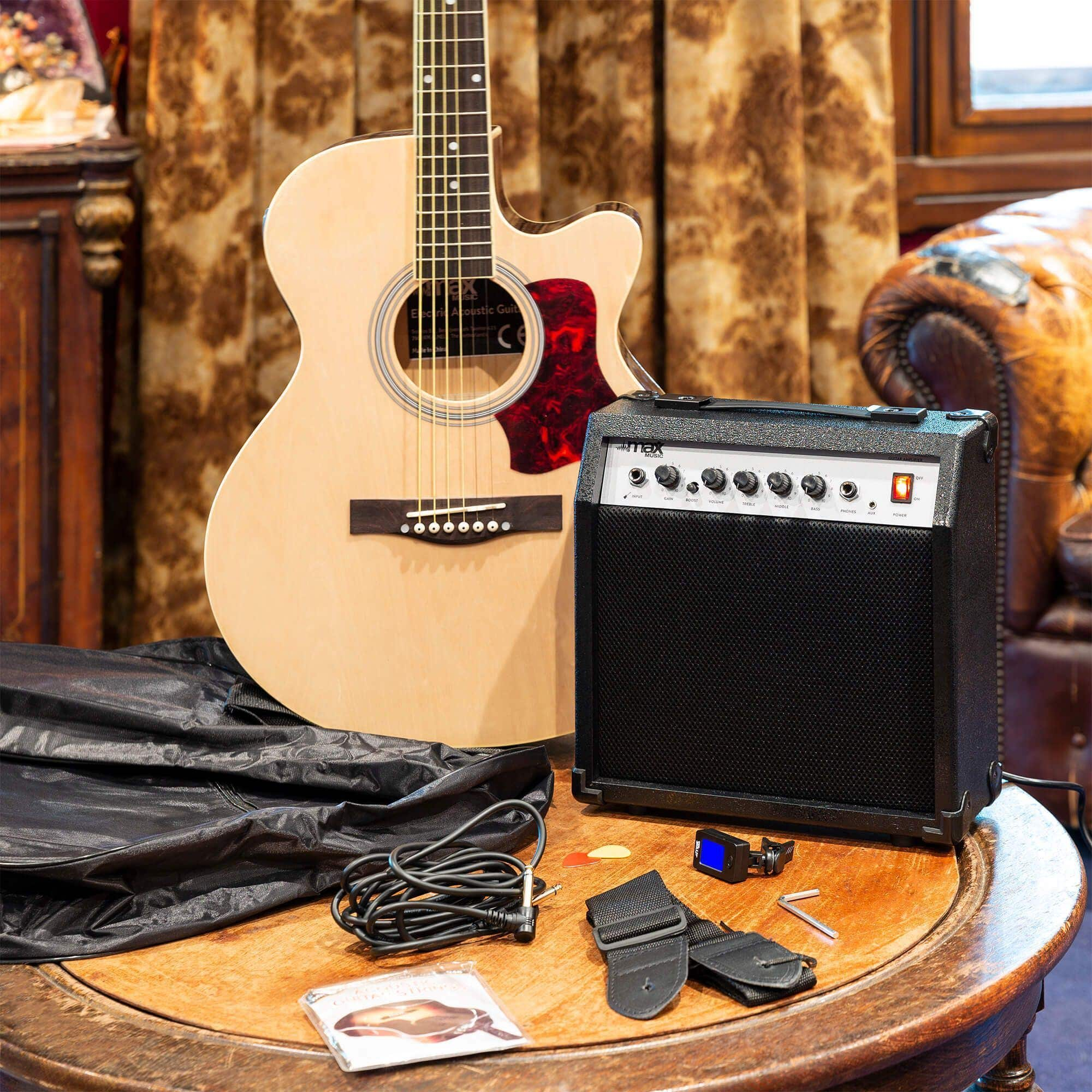 Akoestische gitaar, versterker, accessoires op een tafel bij een gordijn.