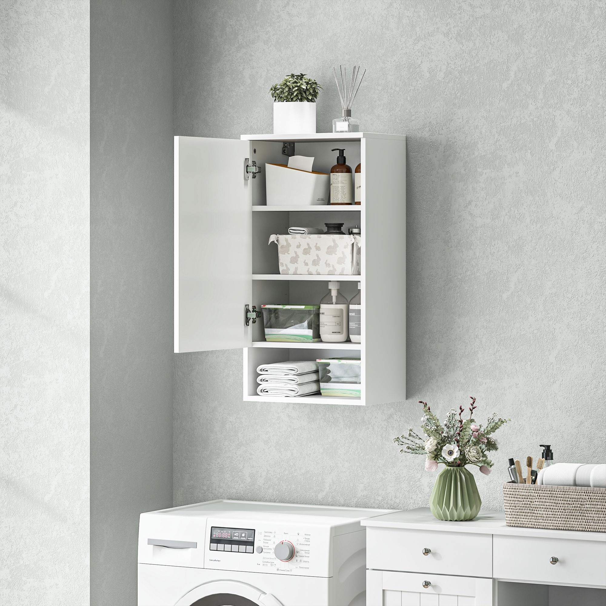 Weißer Medizinschrank geöffnet, enthüllt Toilettenartikel. Waschmaschine im Hintergrund. Graue Wand.