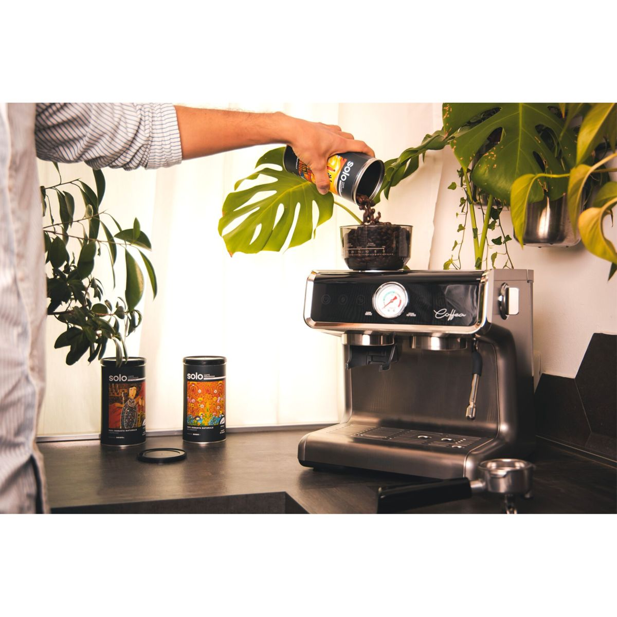 Eine Person gießt Kaffee aus einer Dose in eine Kaffeemaschine.
