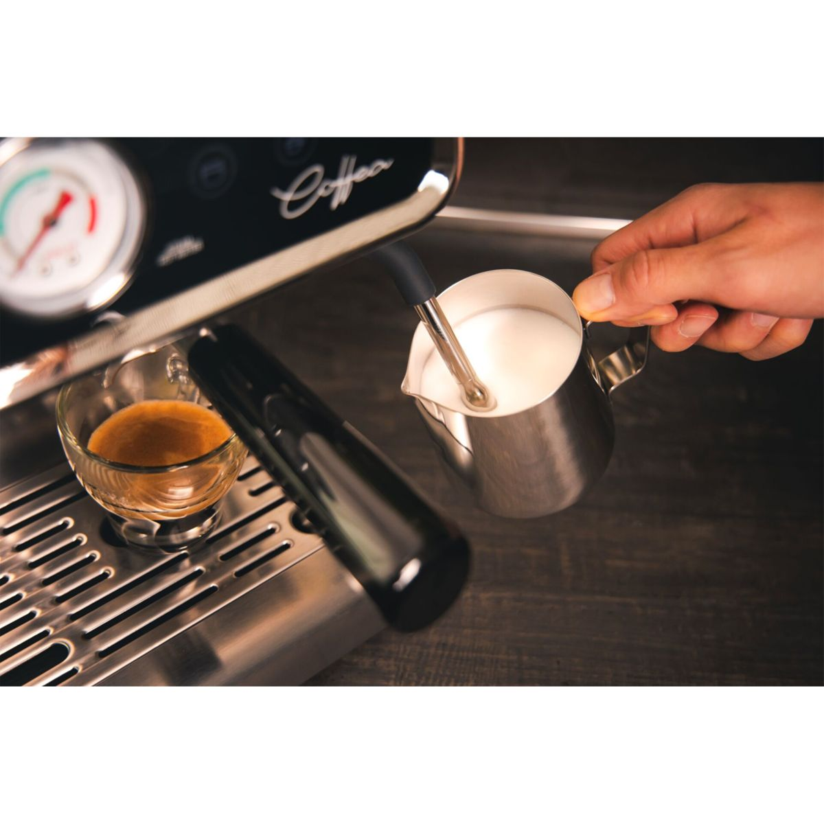 Eine Person schäumt Milch mit einem Dampfgarer für Kaffee auf.