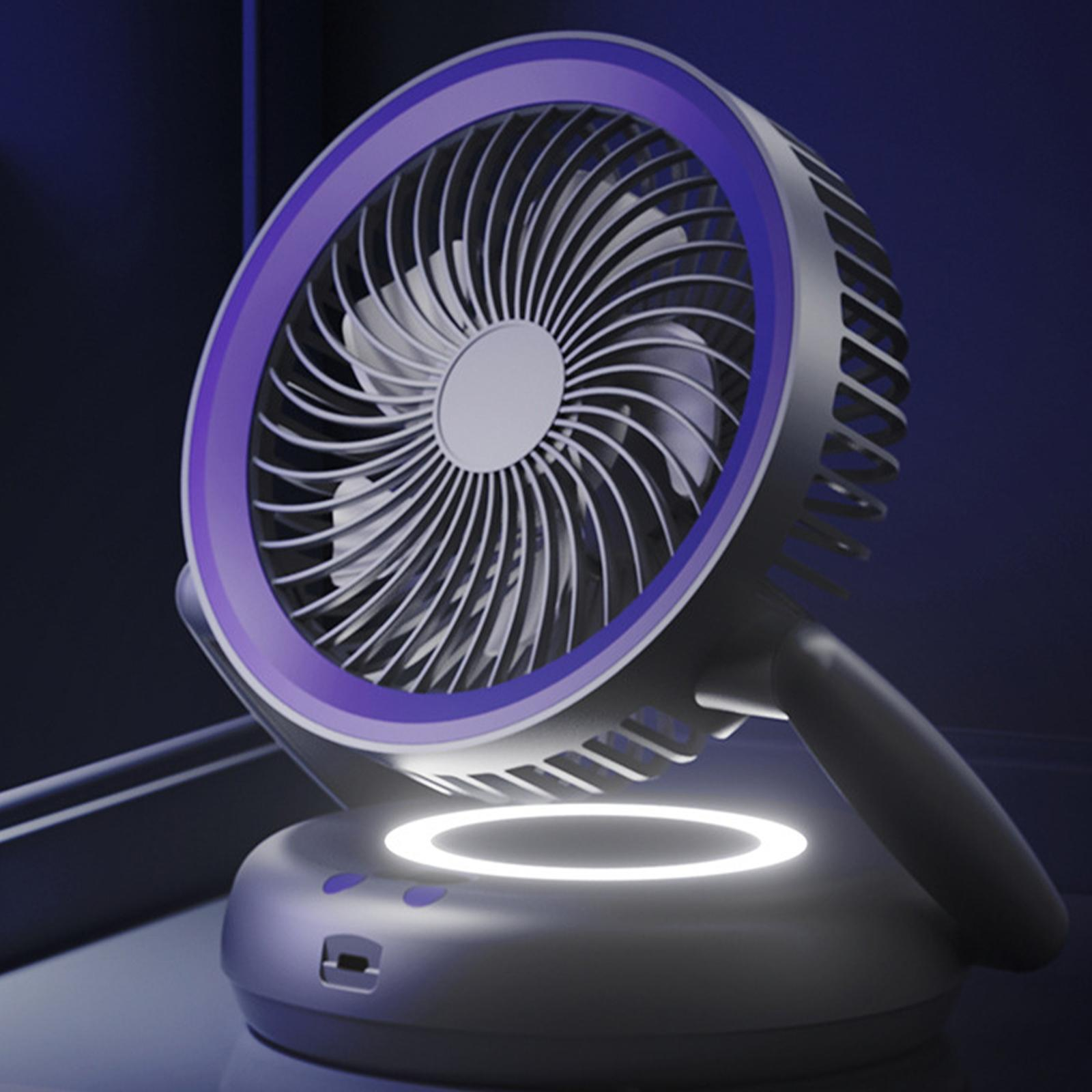 Ein lilafarben gerahmter, grauer Ventilator mit Griff steht auf einem kreisförmigen Sockel.