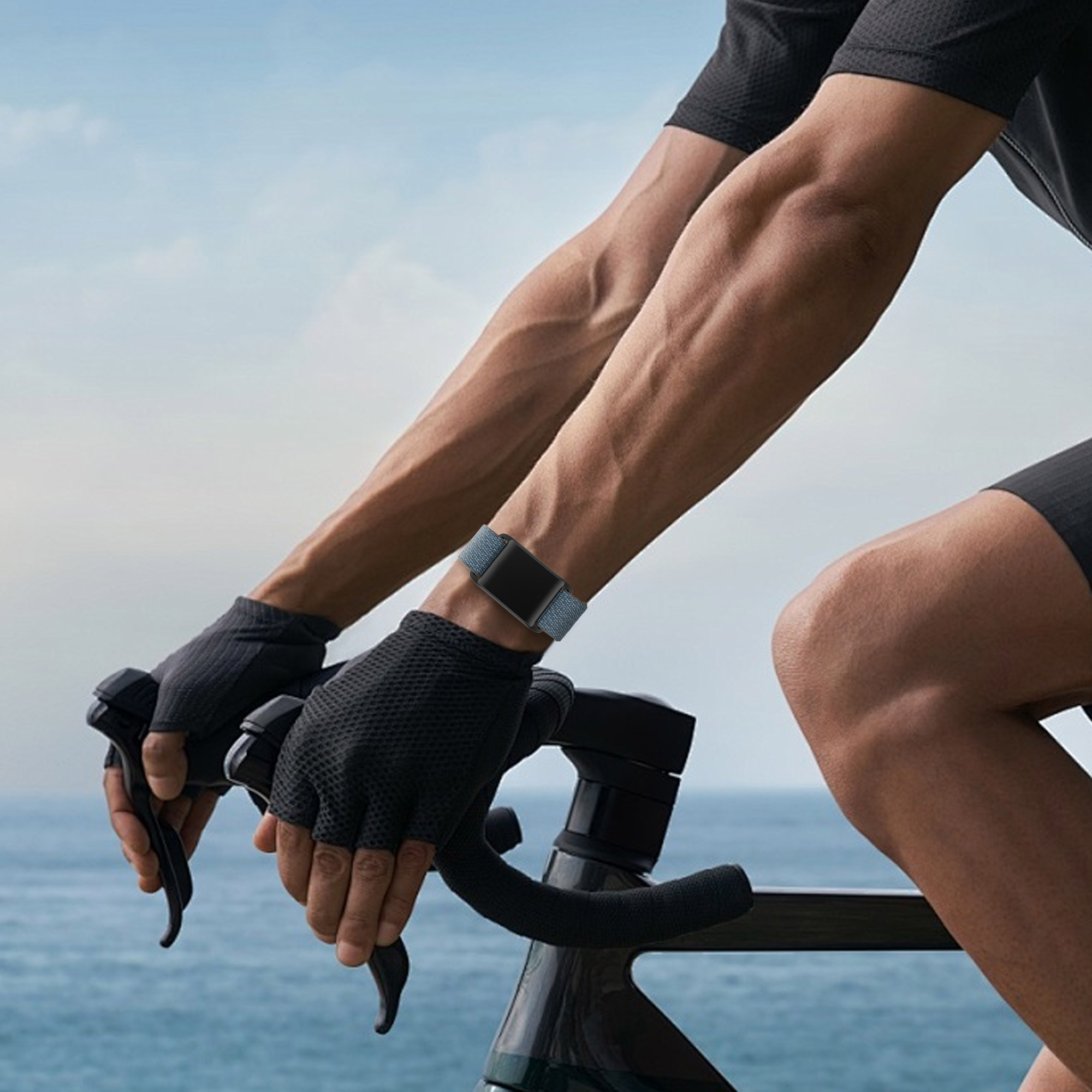 Ein Radfahrer mit Smartwatch-Armband am Handgelenk, der mit dem Fahrrad auf einer Straße fährt.