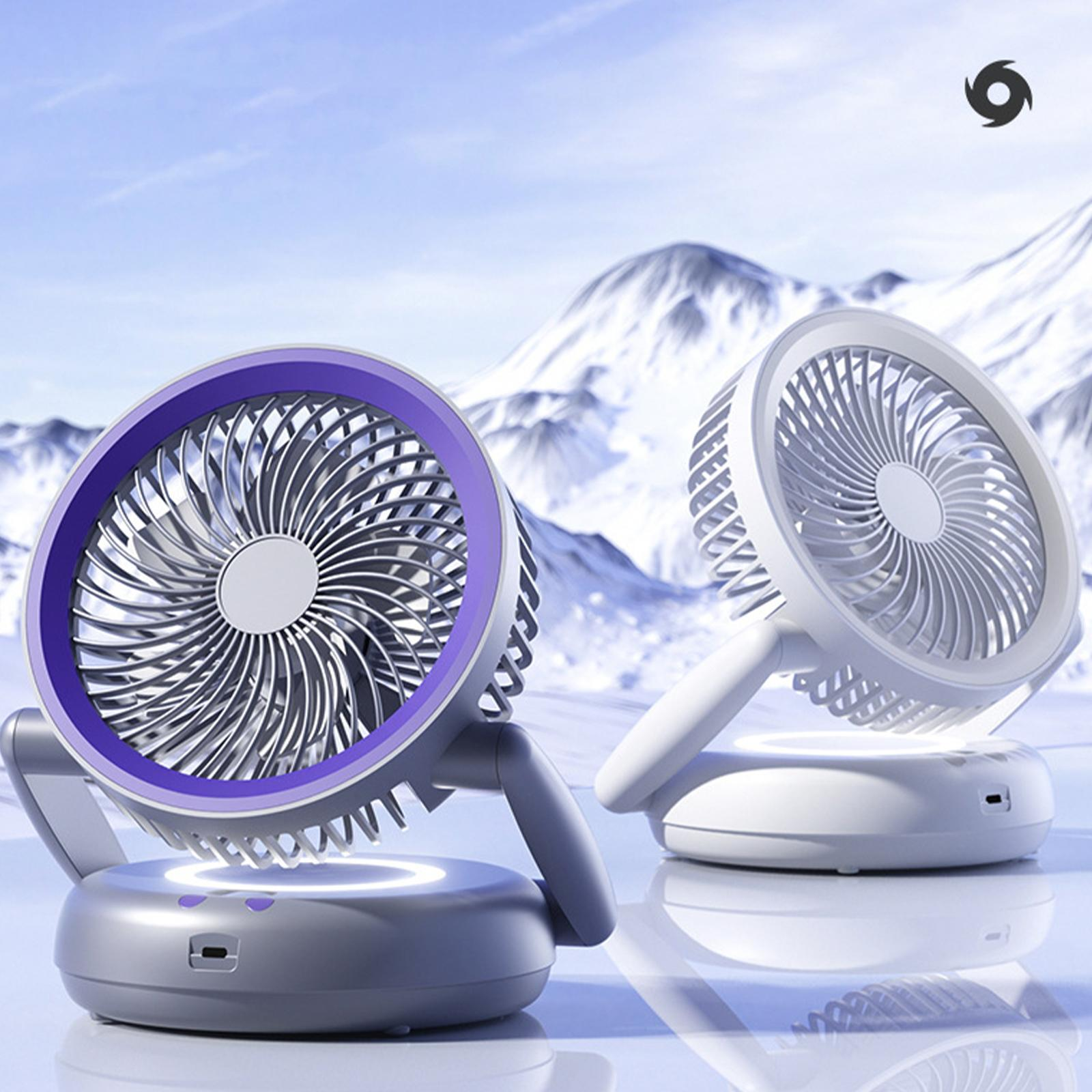 Zwei Ventilatoren, einer lila umrandet, stehen auf Sockeln, mit schneebedecktem Berggrund. Logo oben rechts.