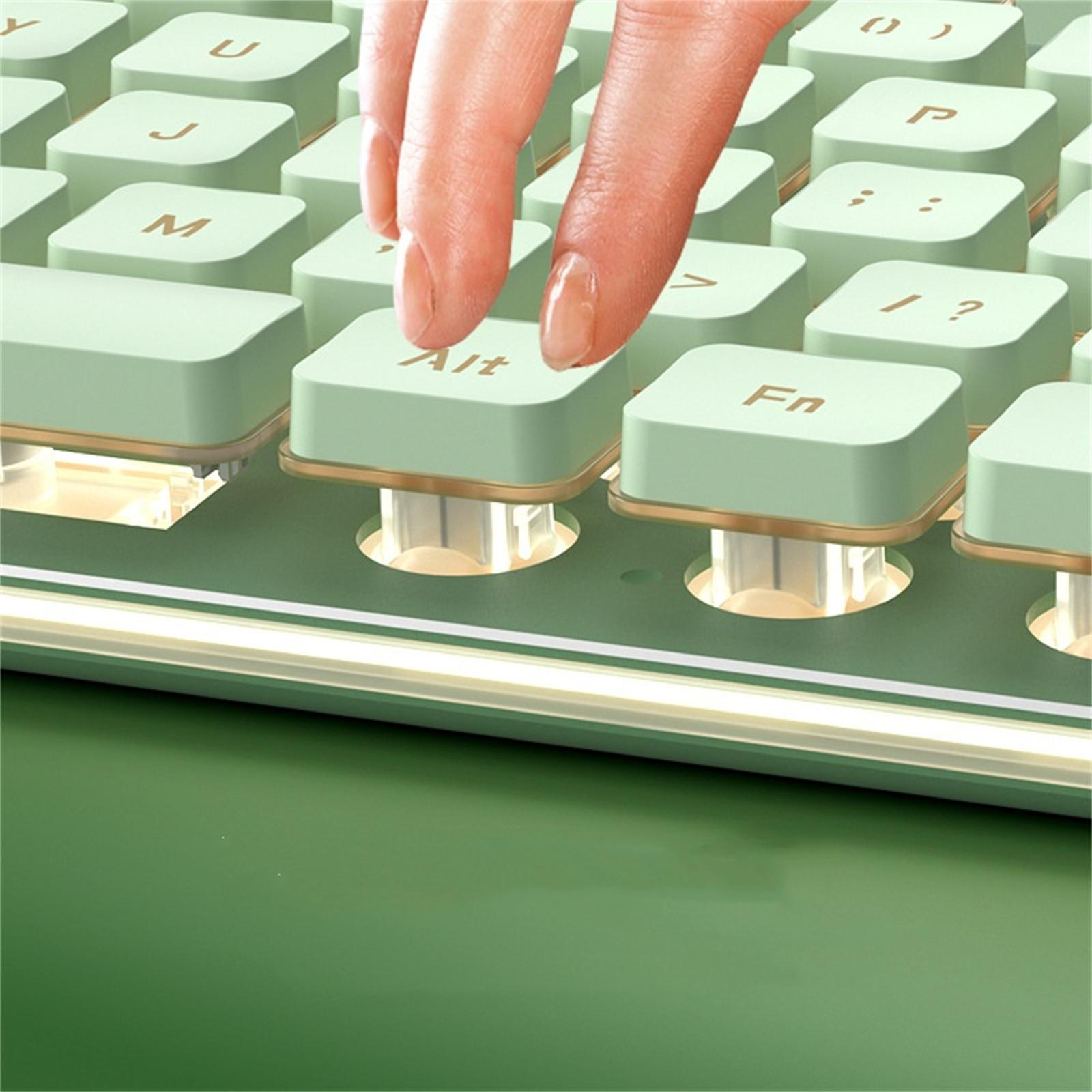 Nahaufnahme einer grünen Tastatur. Ein Finger drückt die Alt-Taste, goldfarbene Akzente am Rahmen.