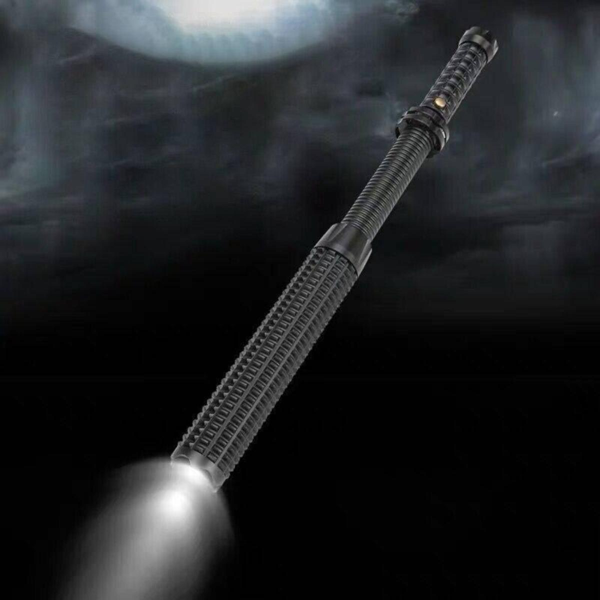 Eine schwarze Taschenlampe, die einen hellen Lichtstrahl vor einem dunklen, bewölkten Hintergrund aussendet.