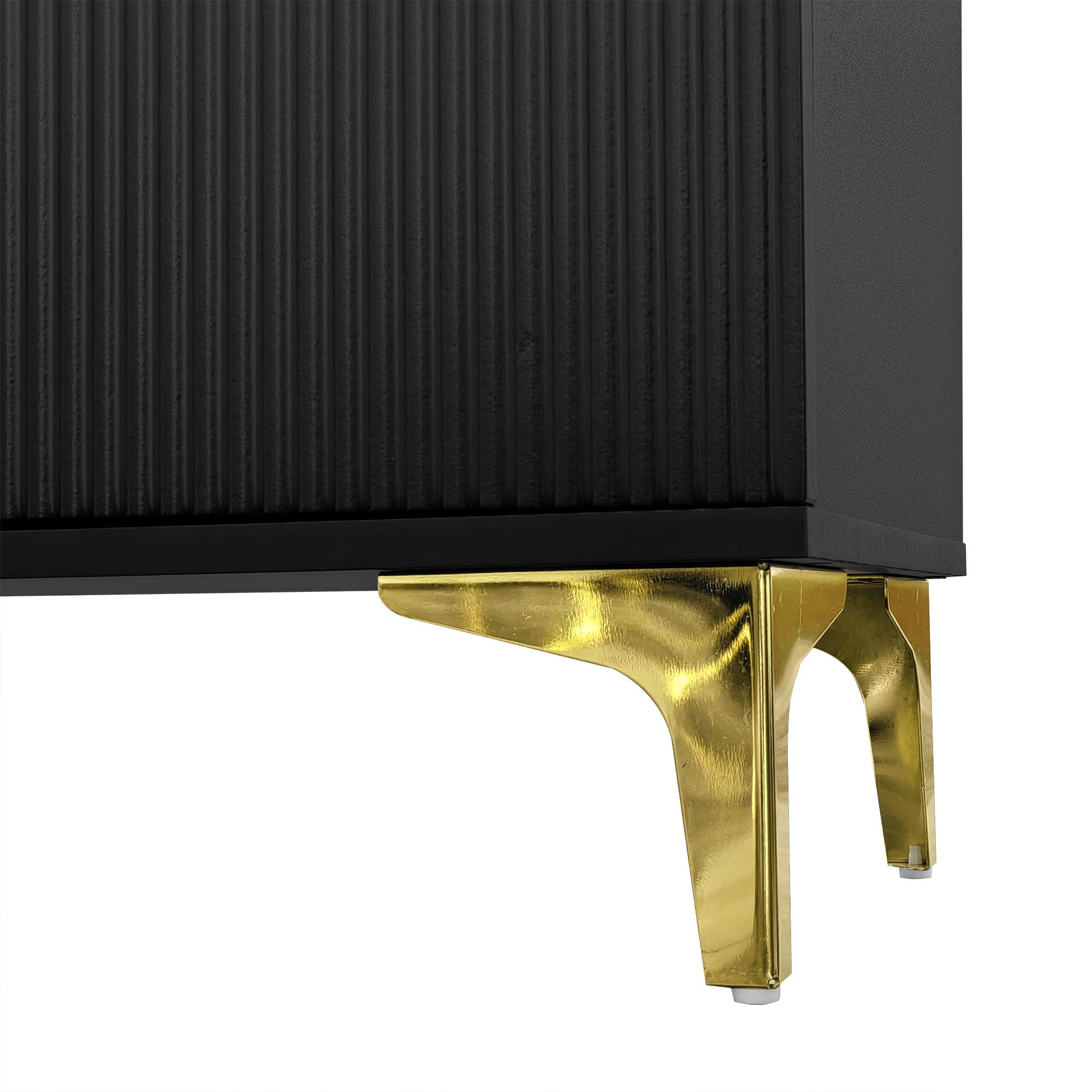 Schwarzer Schrank mit goldenen Beinen, gerippter Front und weißem Hintergrund.