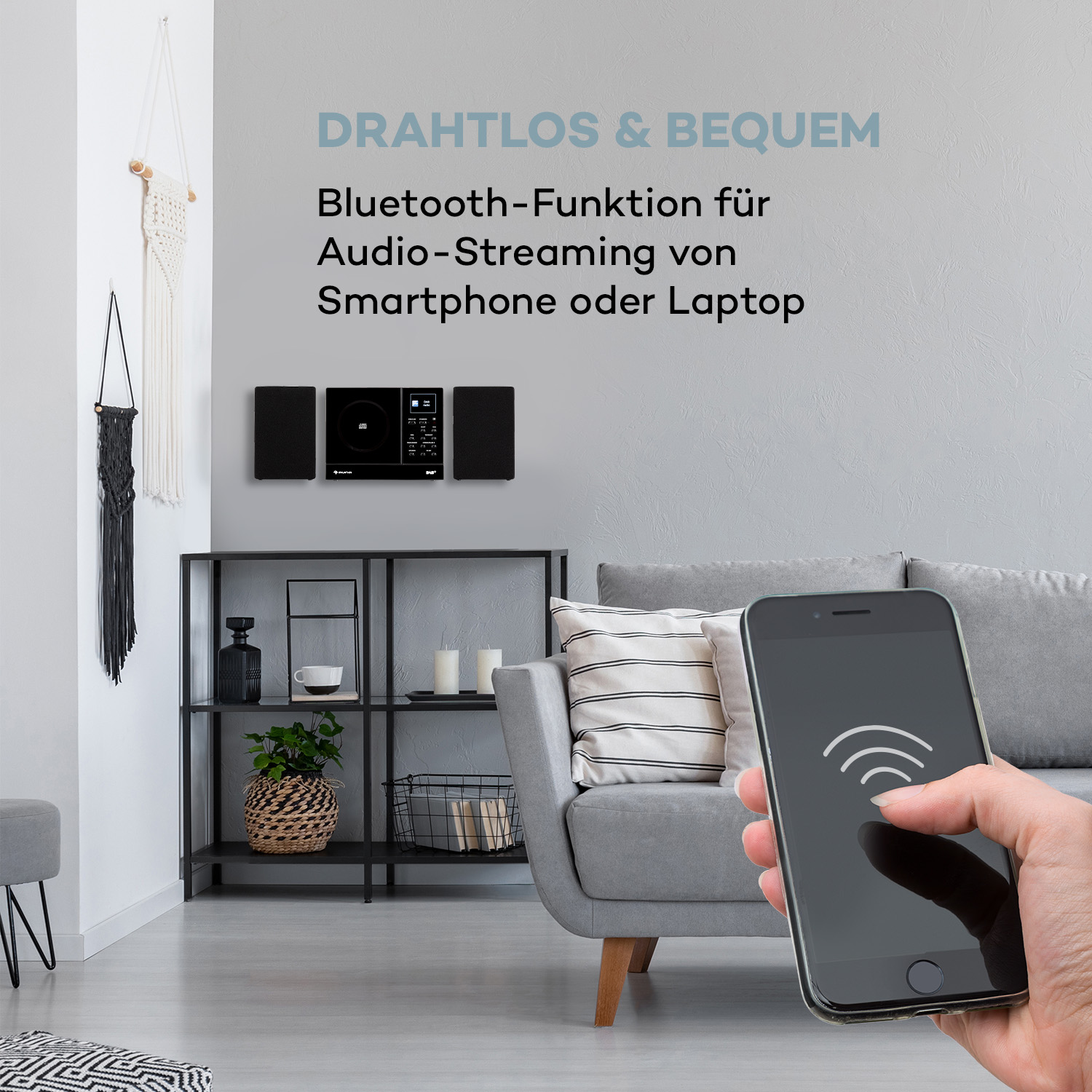 Stereoanlage mit Telefon und Text 'DRAHTLOS & BEQUEM' vor grauem Hintergrund.