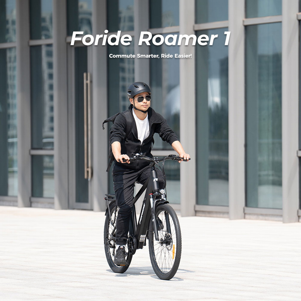 Mężczyzna jadący czarnym rowerem elektrycznym w słoneczny dzień. Czarny kask, ubrania. Logo FORIDE.