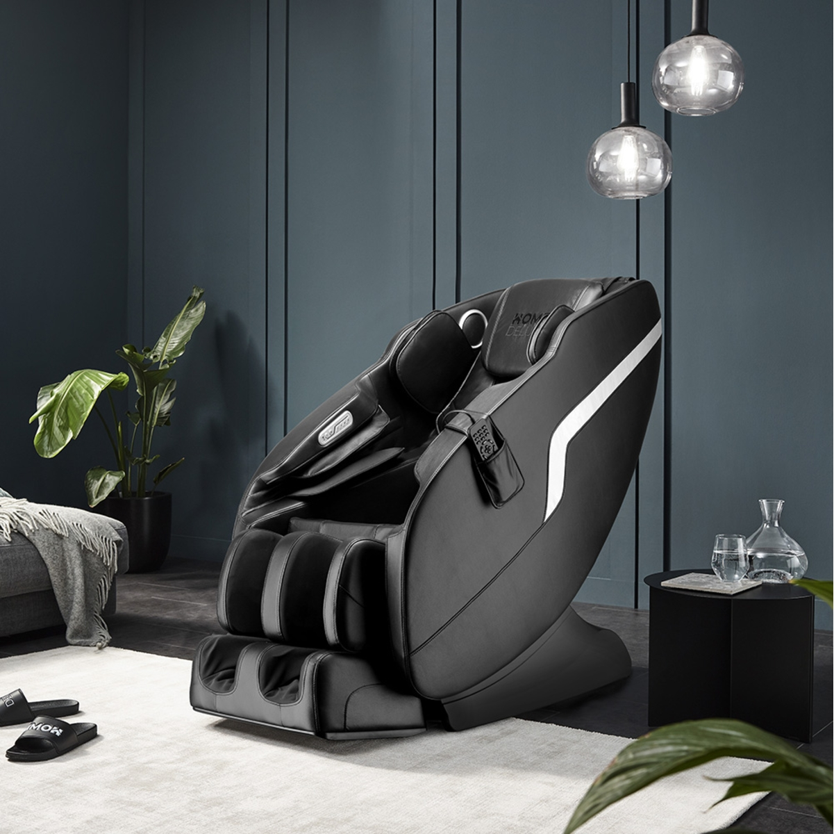 Schwarzer Massagesessel mit weißen Akzenten, in der Nähe von Sofa und Tisch.
