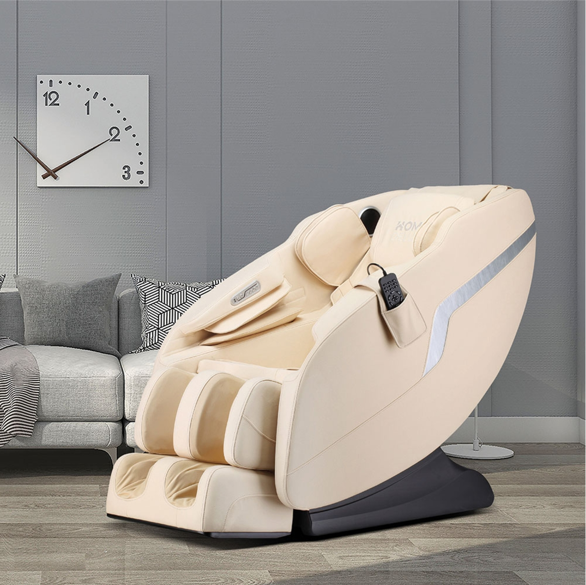 Cremefarbener Massagesessel mit Uhr an der Wand und grauem Sofa, in Raumumgebung.