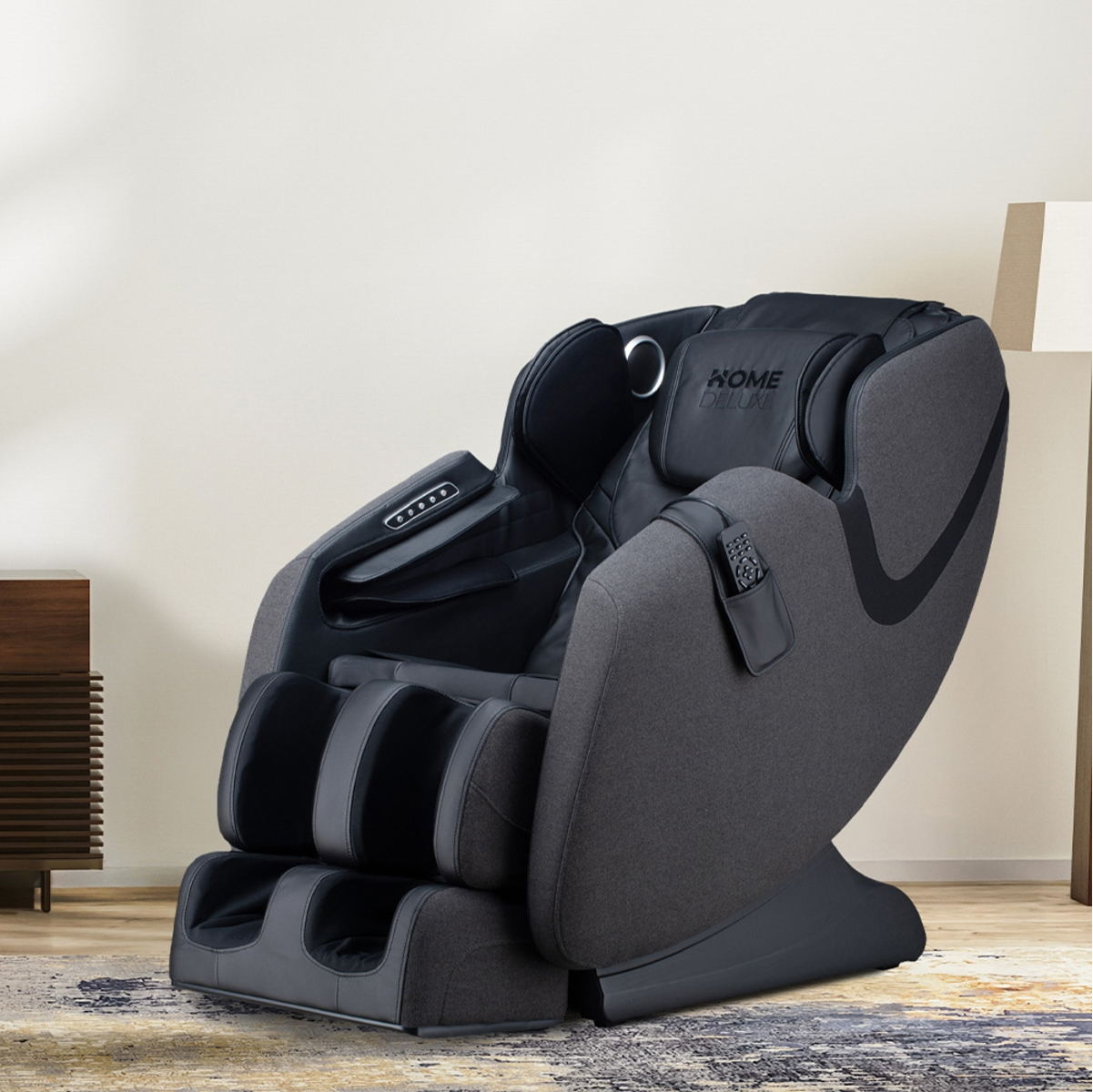 Grauer Massagesessel mit schwarzen und grauen Akzenten, in Raumumgebung mit Holzschrank.
