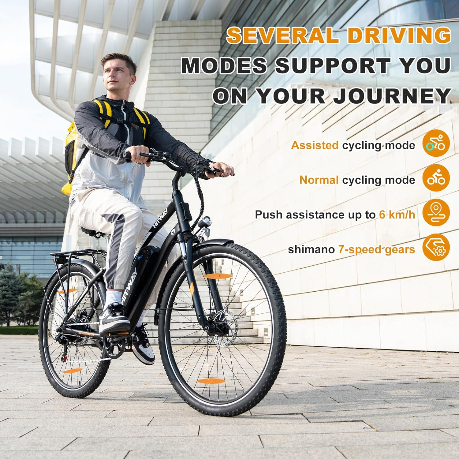 Mężczyzna na czarnym rowerze elektrycznym. Tekst: Kilka trybów jazdy. Tło: Nowoczesny budynek i chodnik.