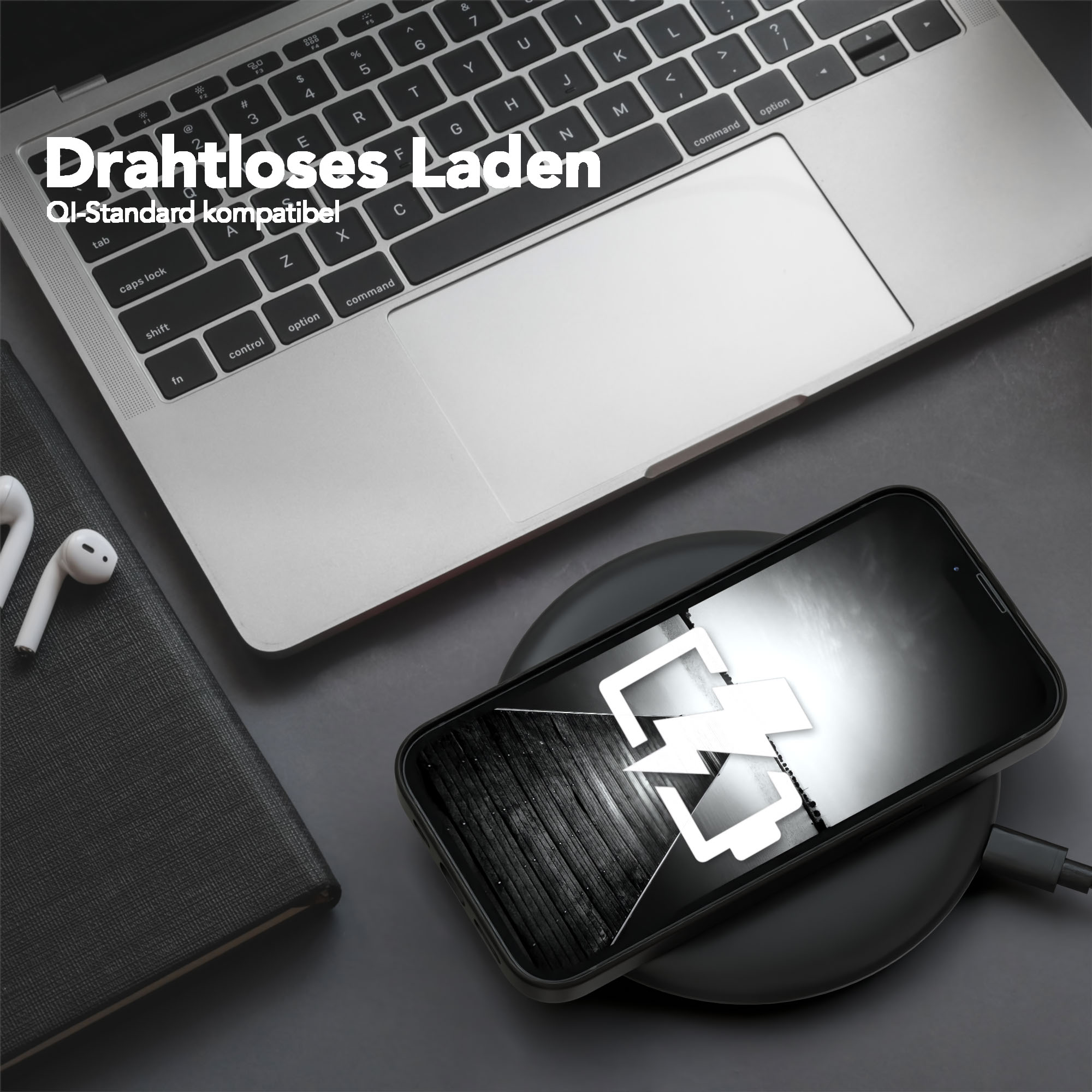 Ein Telefon auf einem kabellosen Ladegerät mit einem Laptop und einem Notizbuch im Hintergrund.