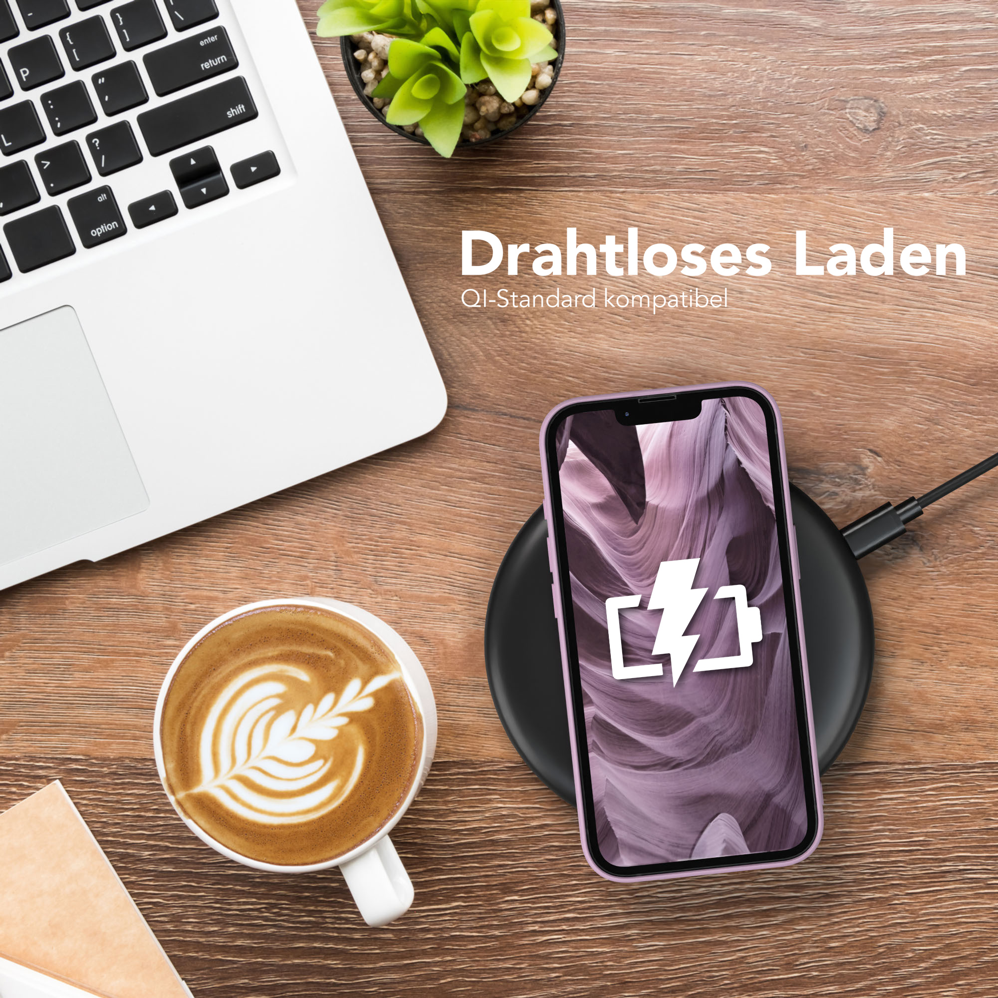 Ein Telefon, das drahtlos geladen wird, mit Kaffee und Laptop auf dem Holztisch. Eine kleine Pflanze im Hintergrund.