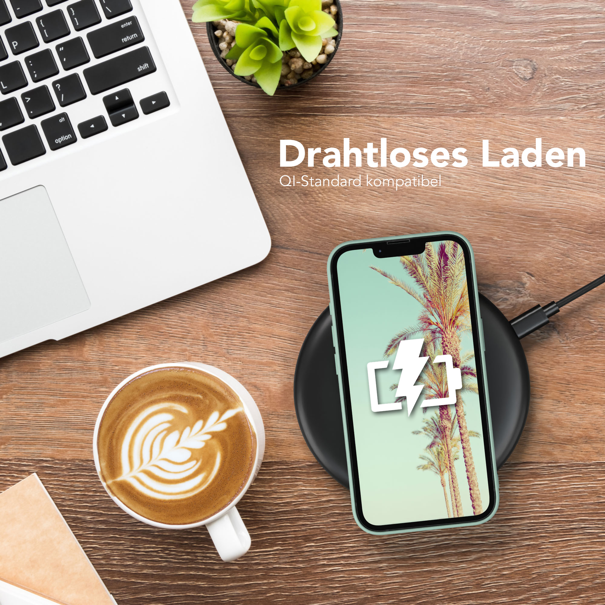Telefon auf kabellosem Ladegerät, Laptop, Kaffeetasse, Telefon zeigt Ladesymbol und Palmen.