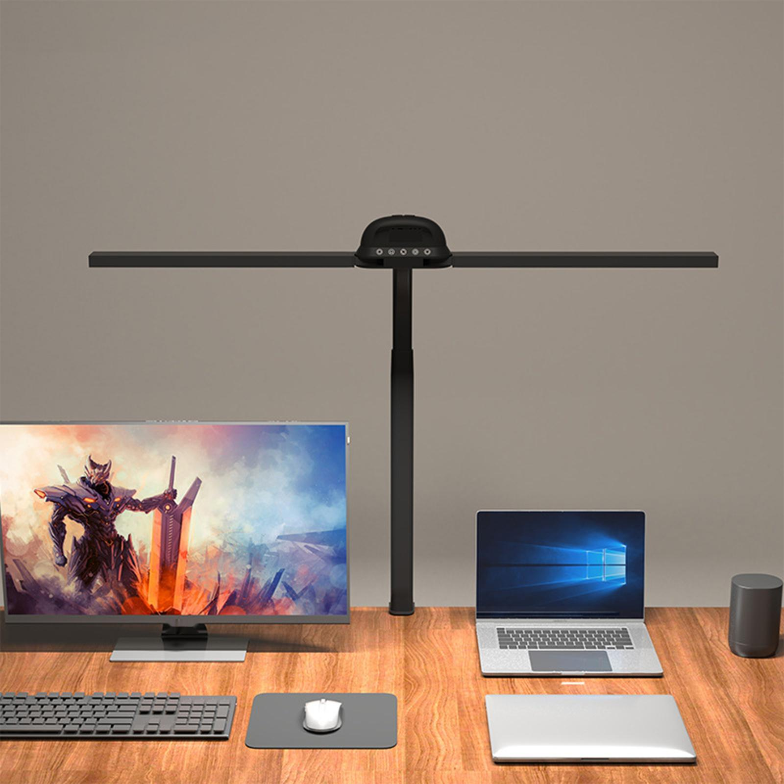 Ein Schreibtisch mit Monitor, Laptop, Lampe, Tastatur und Maus.