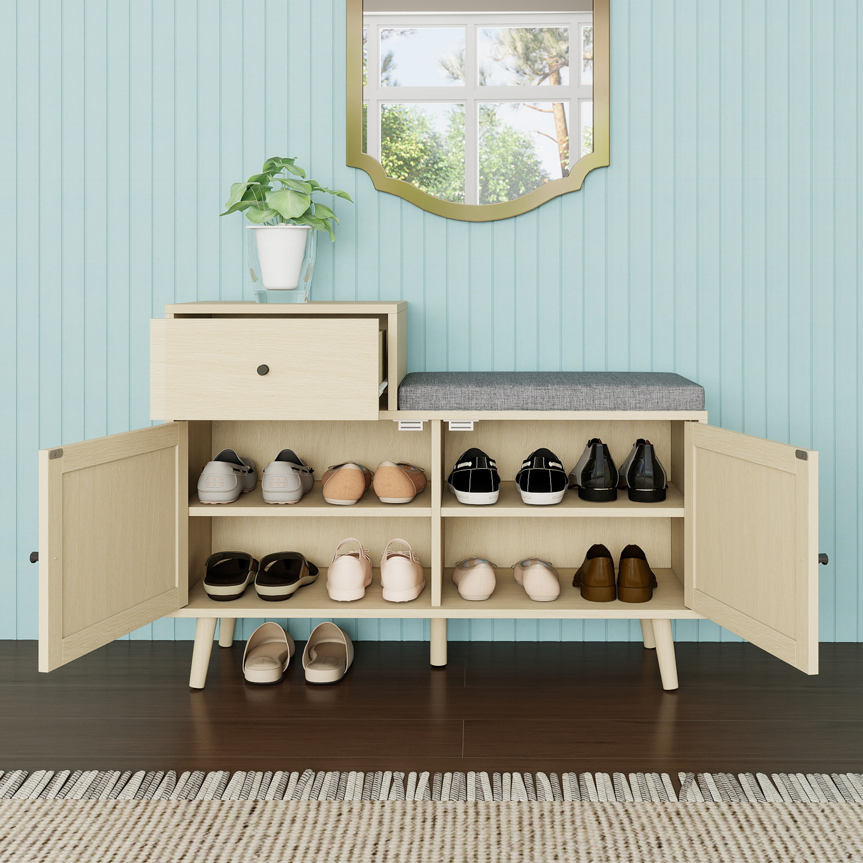 Beige Schuhaufbewahrungsbank mit Schuhen, Spiegel und Pflanze.