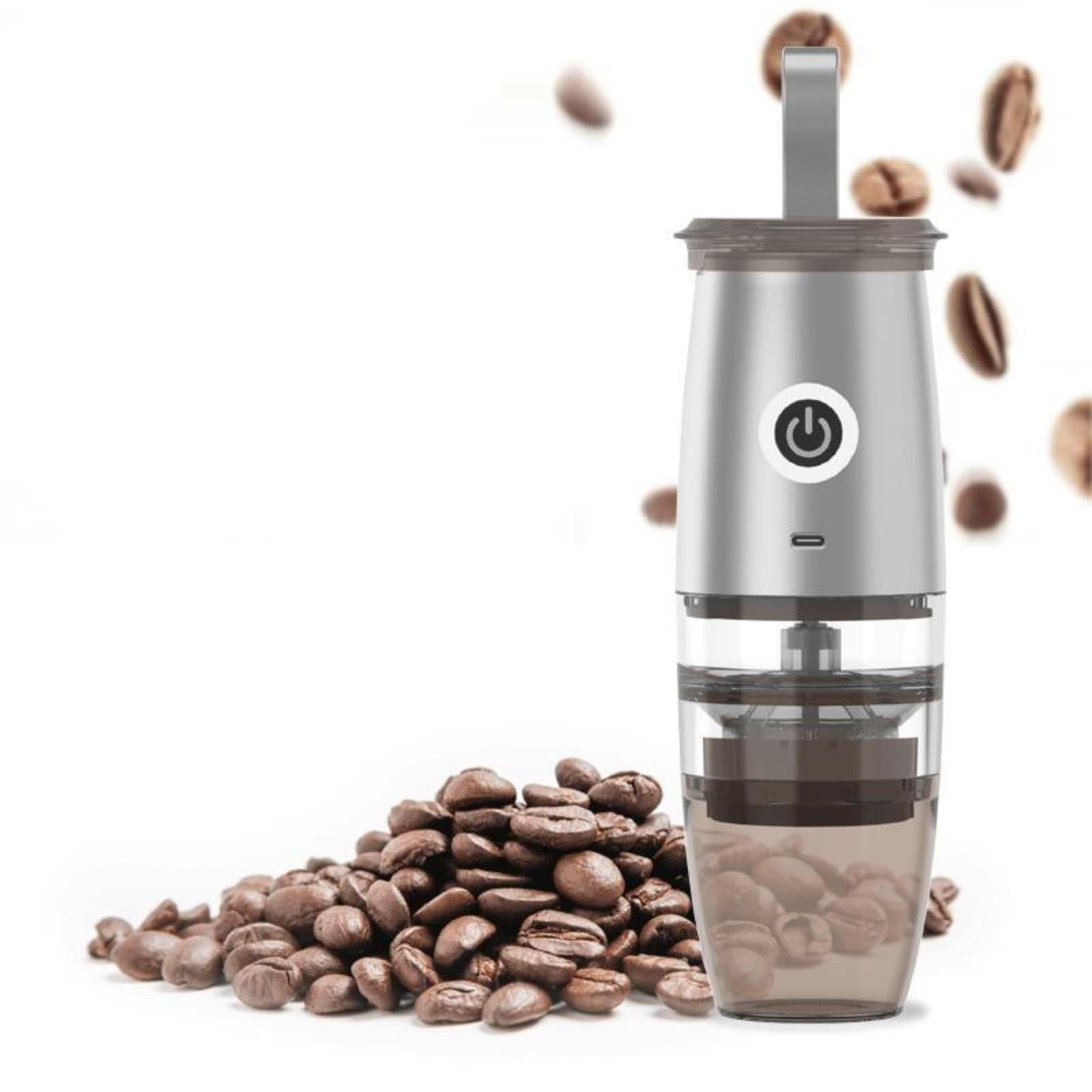 Silberner Kaffeemühle mit Bohnen daneben.