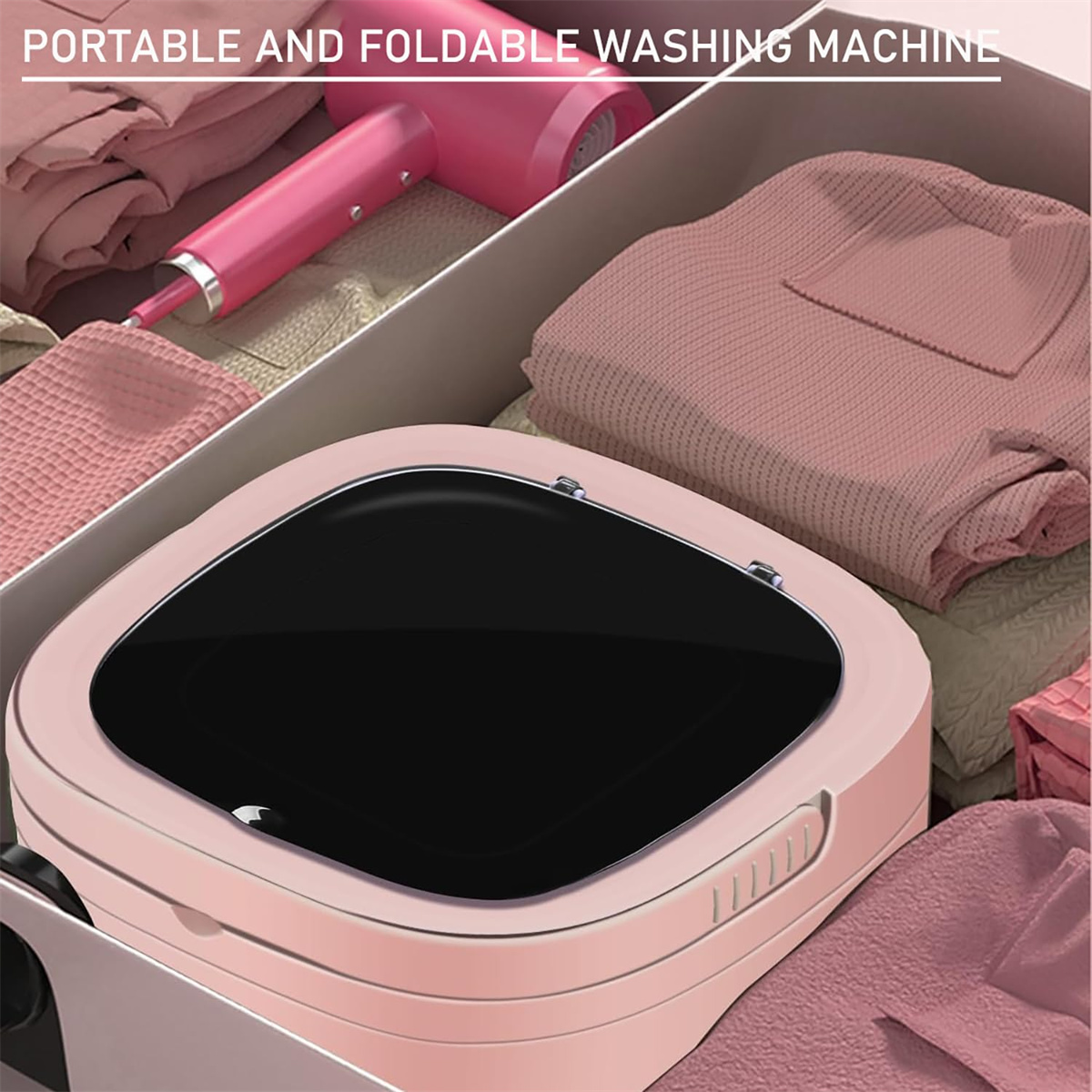 Eine pinkfarbene, faltbare Waschmaschine in einer Schublade. Ein pinkfarbener Haartrockner und Kleidung befinden sich in der Schublade.