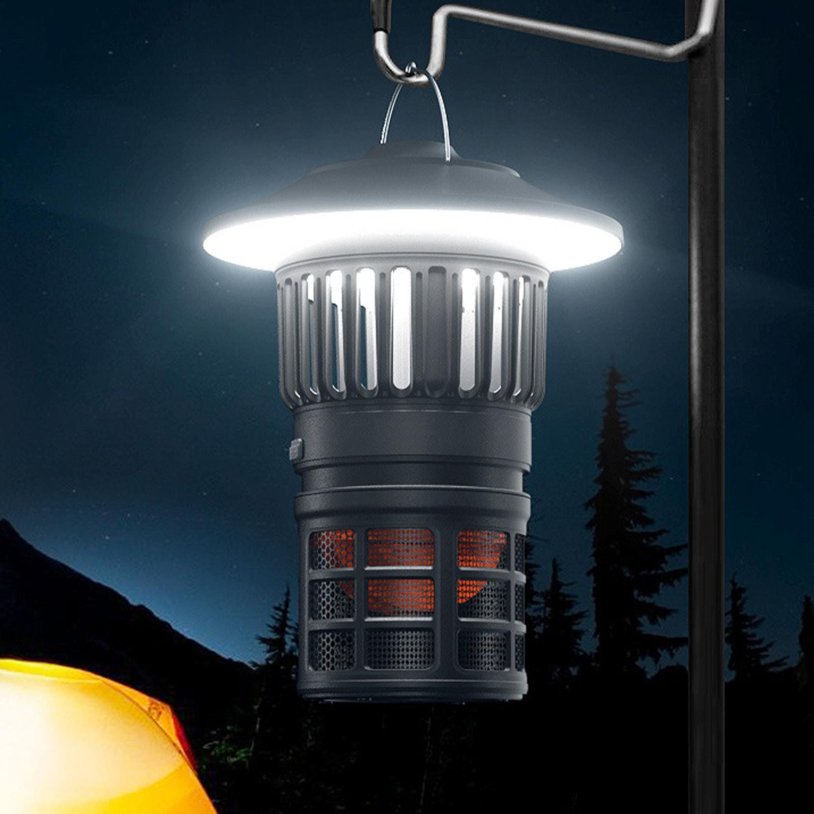 Laterne im Freien mit hellem, weißem Licht. Sie hängt nachts an einer Metallstange, im Hintergrund ein Zelt.