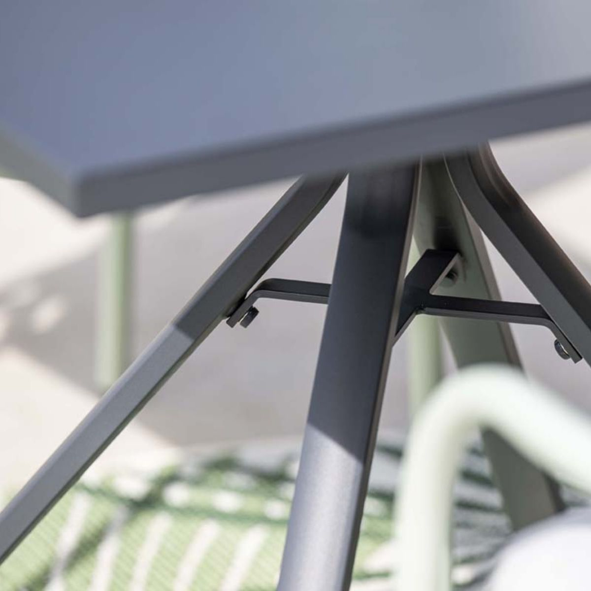Close-up van de voet van een tafel. Zwarte poten ondersteunen de tafel.