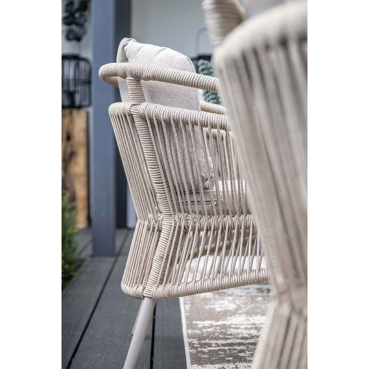 Side view of outdoor chairs with woven rope design and light-colored cushions.