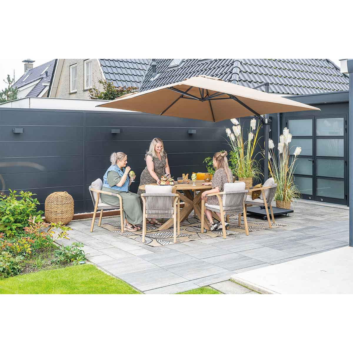 Mensen die aan tafel zitten met parasol. Buitenomgeving.