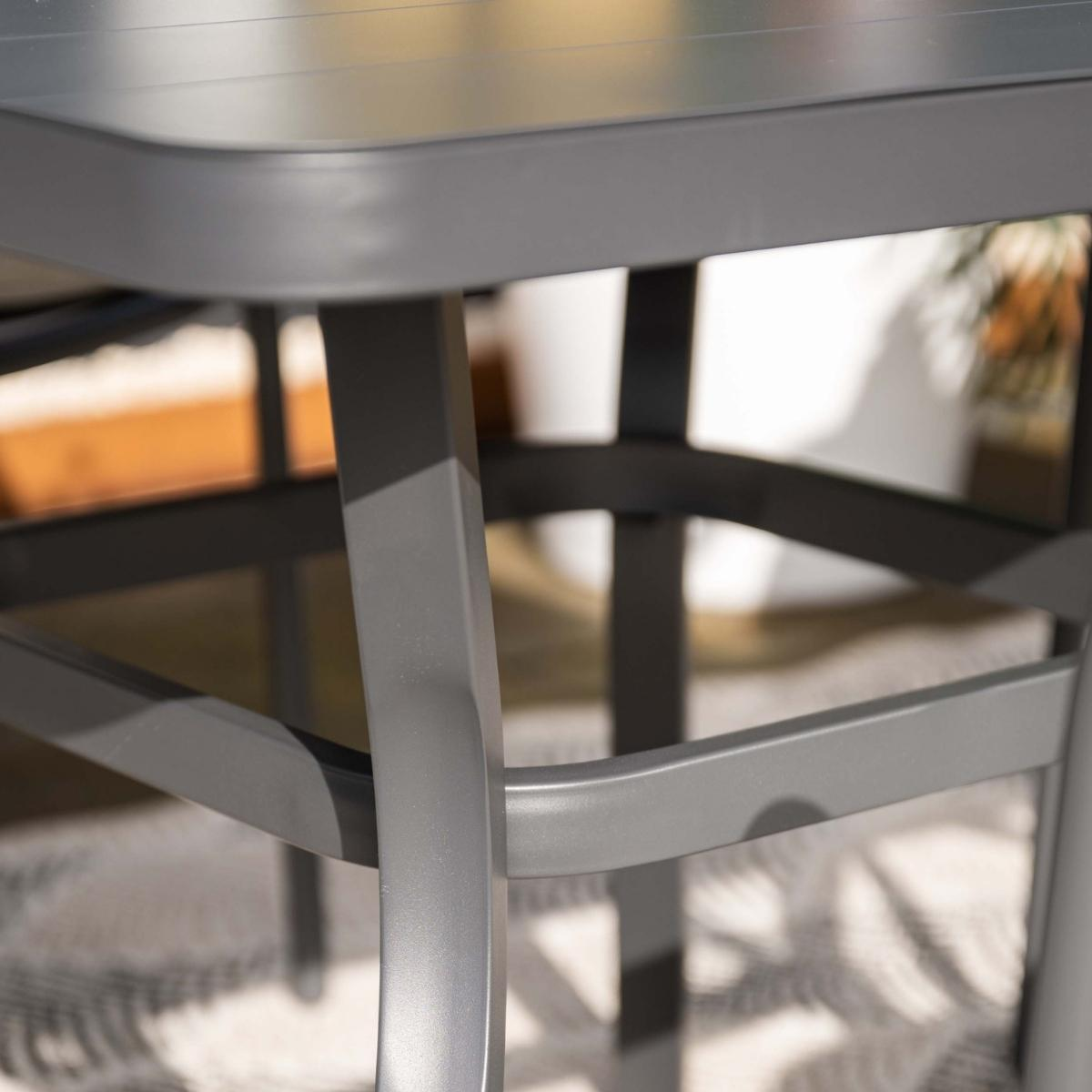 Close-up of a table leg with a curved metallic element.