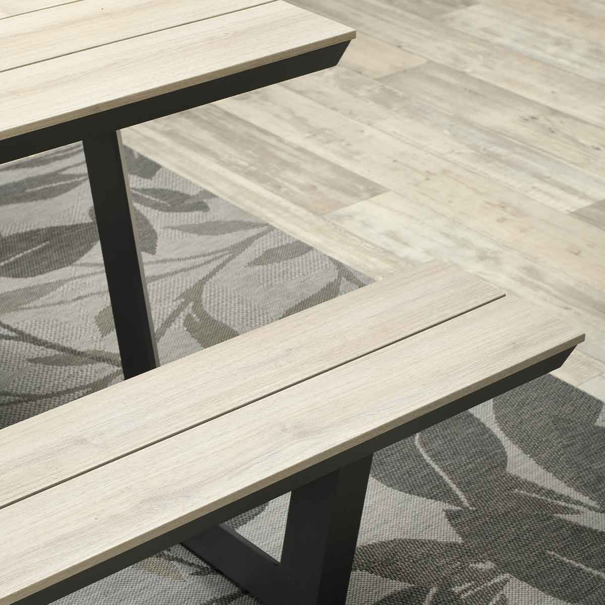 Gros plan sur le dessus en bois et le banc d'une table de pique-nique. Fond avec tapis.