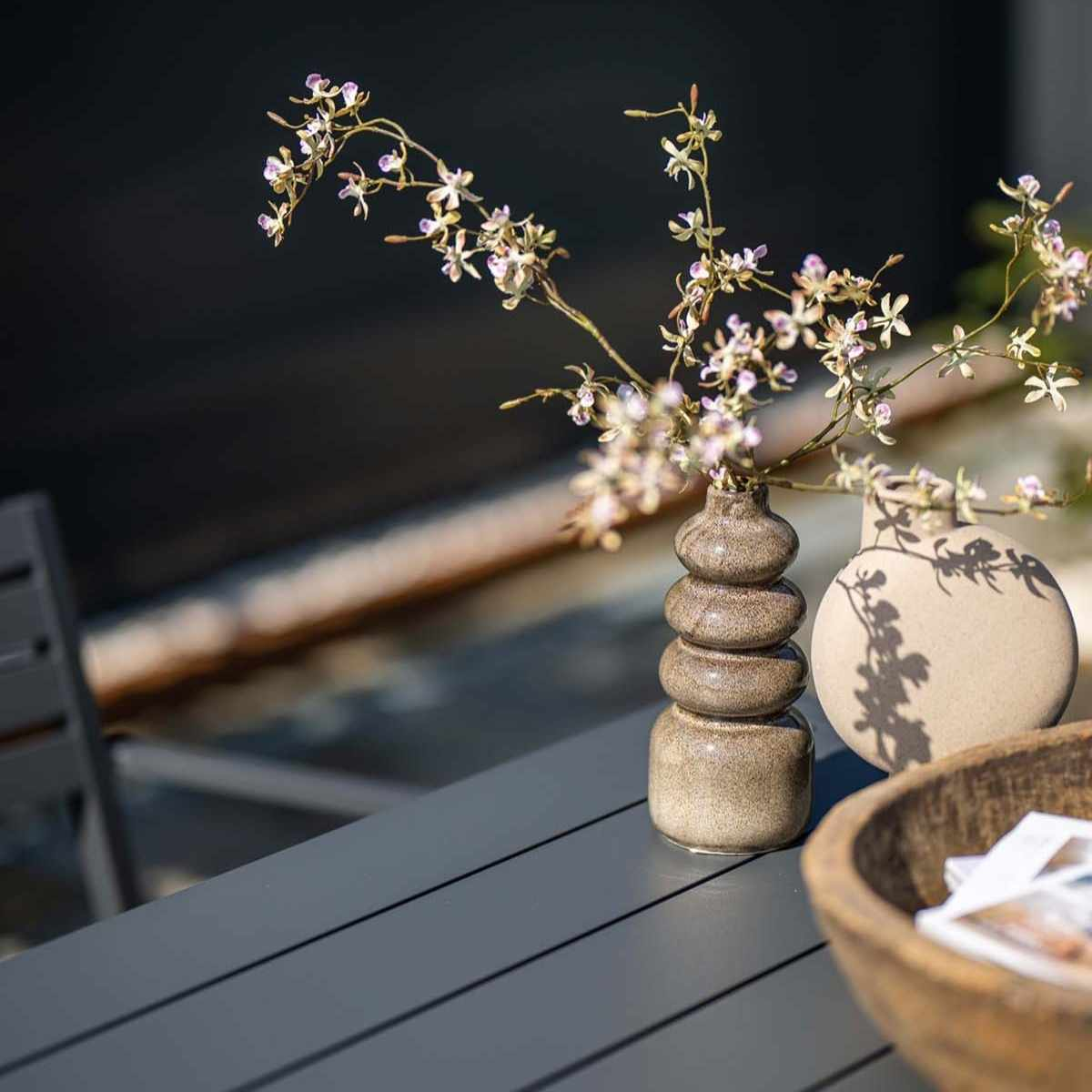 Close-up of a table with flowers.  Vases with flowers are on a dark gray table.