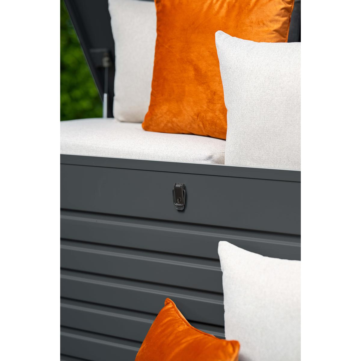 Close-up van een opbergkist voor buiten met oranje en witte kussens erin.