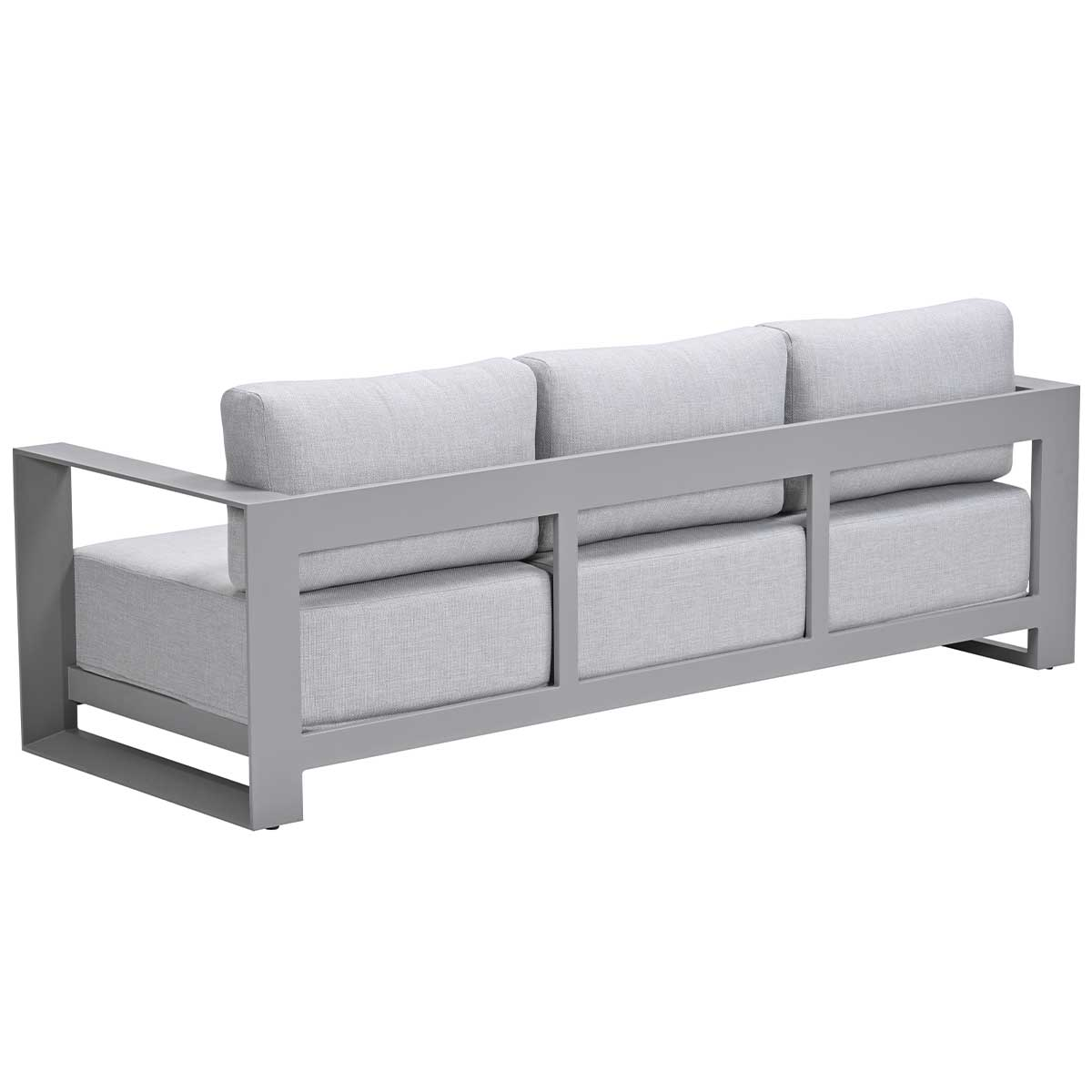 Un canapé gris sur fond blanc. Le canapé a trois coussins gris clair et un cadre métallique.