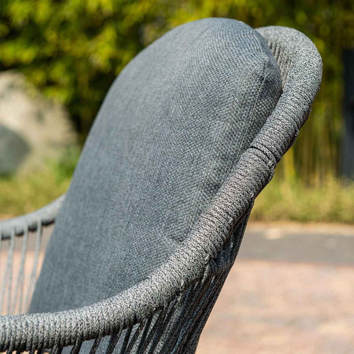 Close up of a grey cushion on a chair. Wicker chair frame.