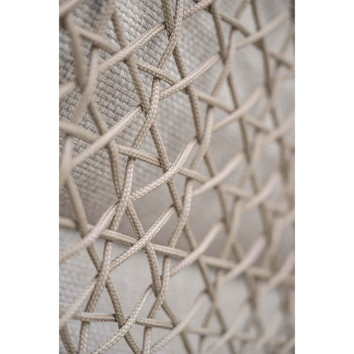 Gros plan sur le détail d'une chaise tissée. Motif tissé beige visible.