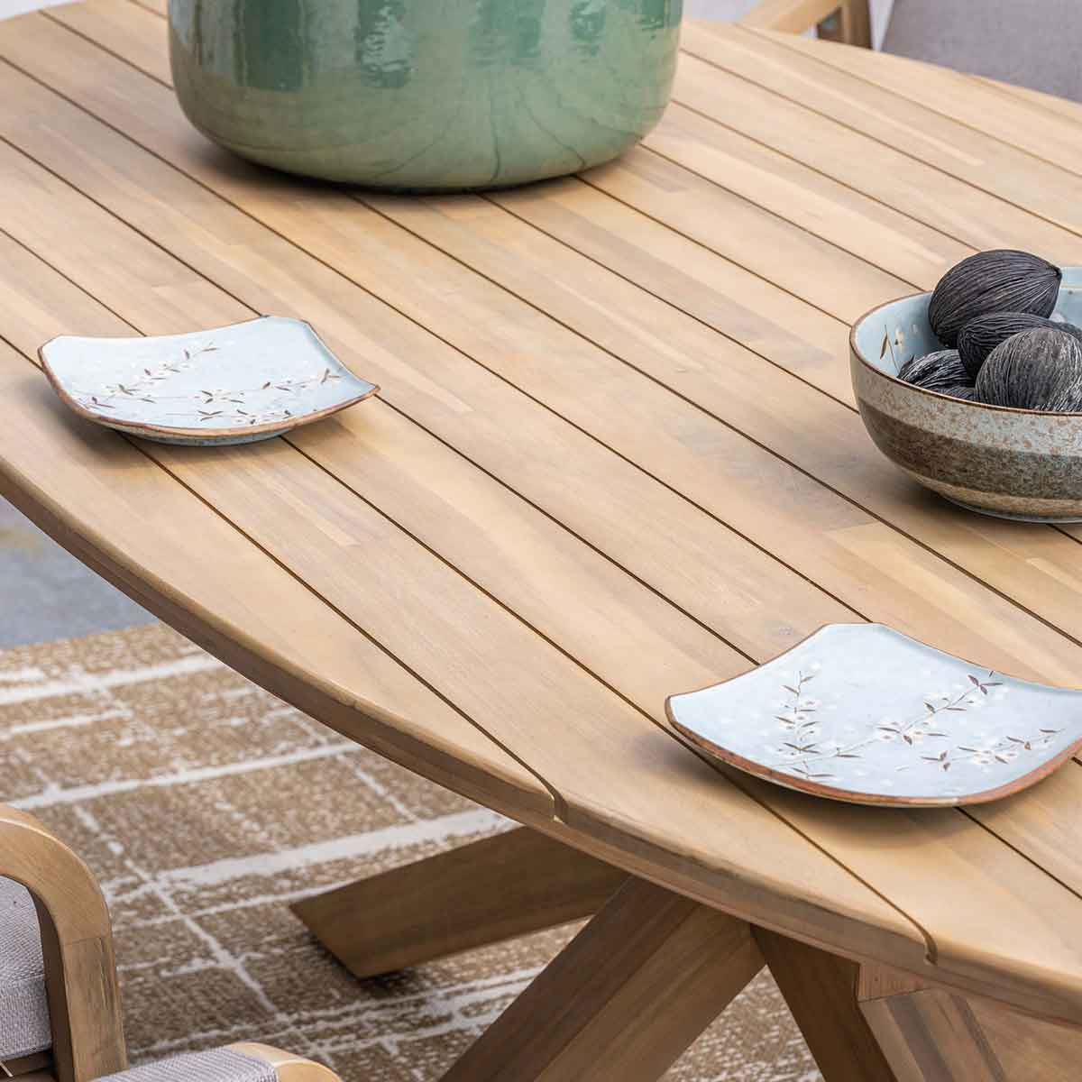 Houten tafel met borden, kommen en decoraties, close-up.