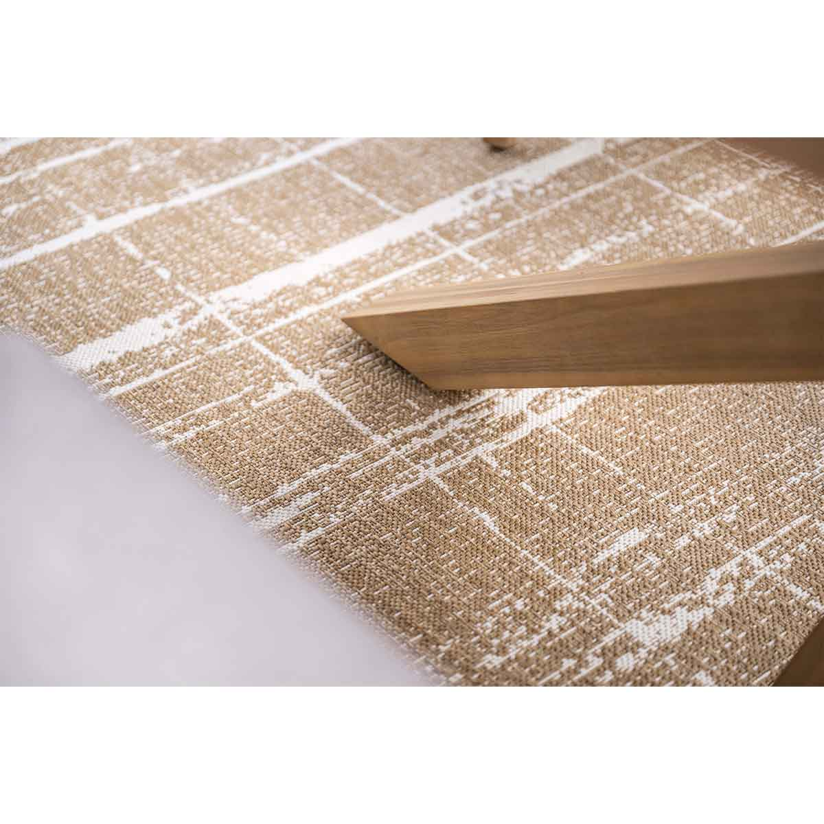 Close-up van een beige en wit getextureerd tafelkleed met hout.