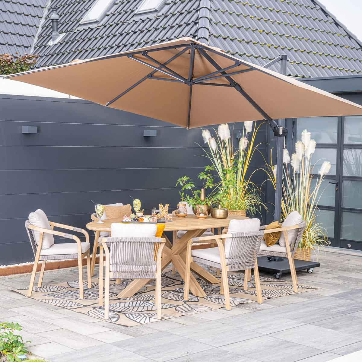 Un ensemble de patio sous un parasol. Table, chaises et plantes sur une terrasse.