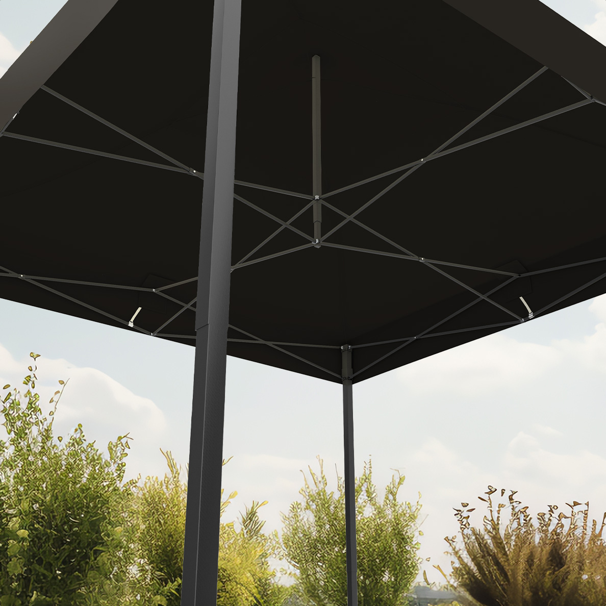 View from below of a black tent roof, with supporting structure, against a cloudy sky and green trees.