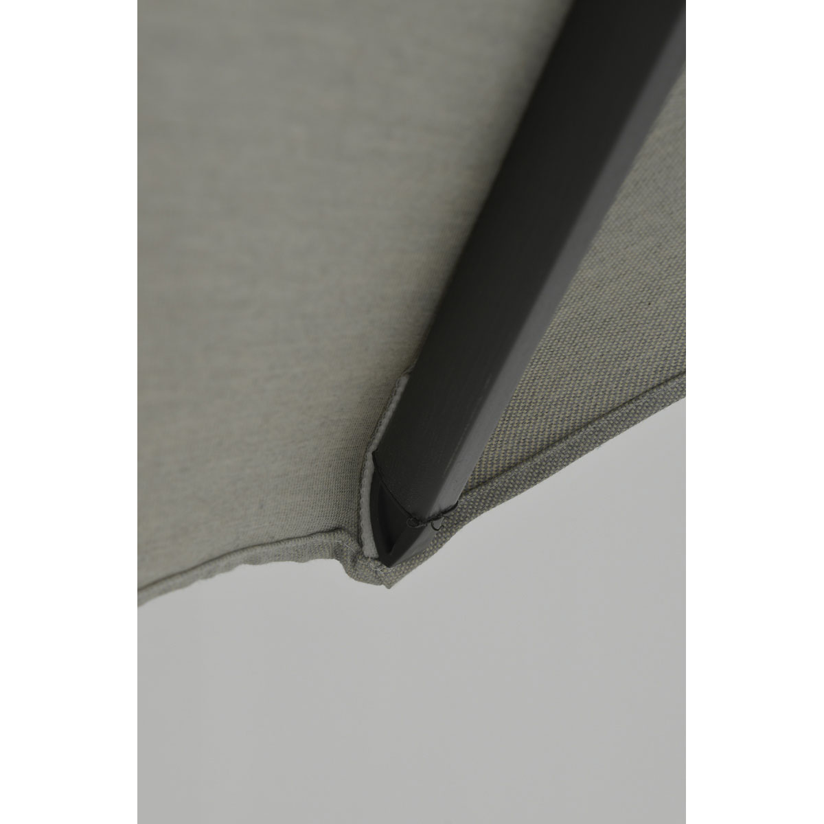 Close-up showing the edge of a gray umbrella's fabric and support structure.
