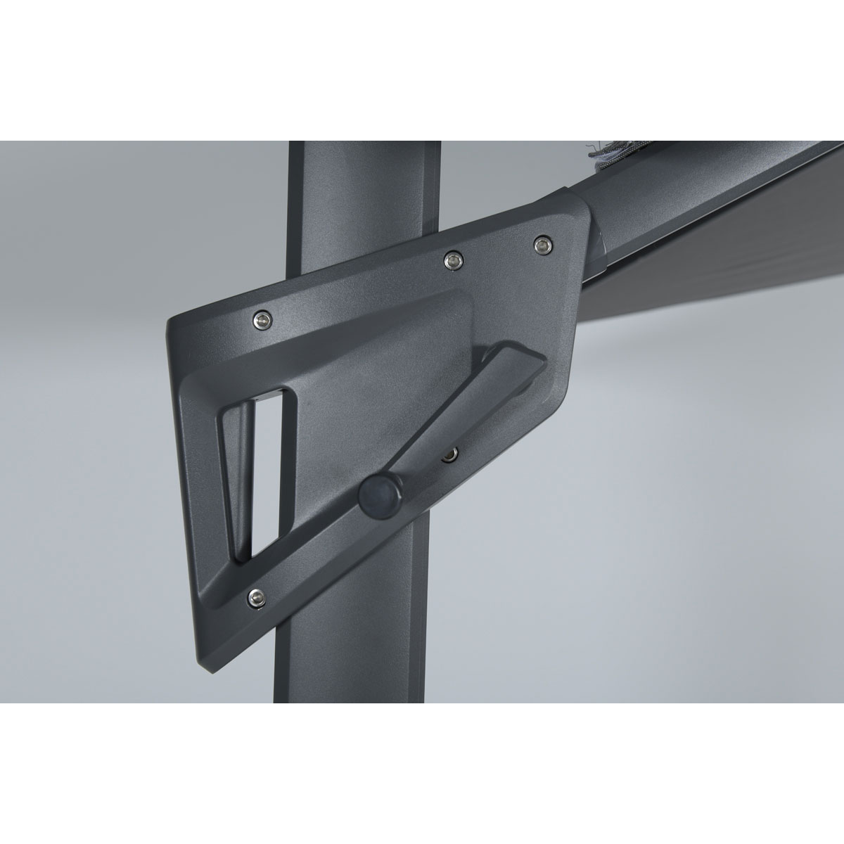 Close-up of a dark gray metal mechanism, with a handle and visible screws on a light gray background.