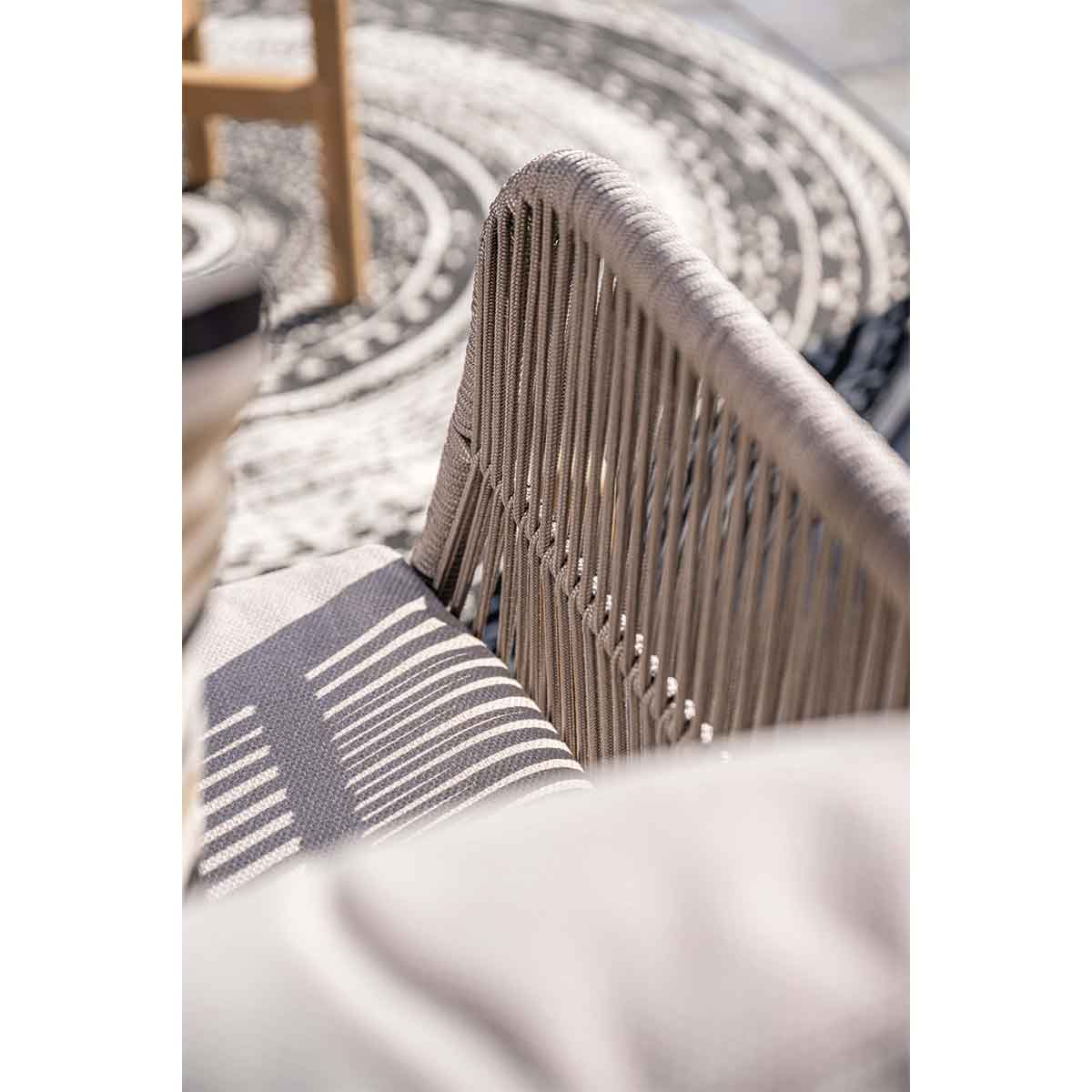 Close-up of chair back, woven rope design. Light gray cushion.