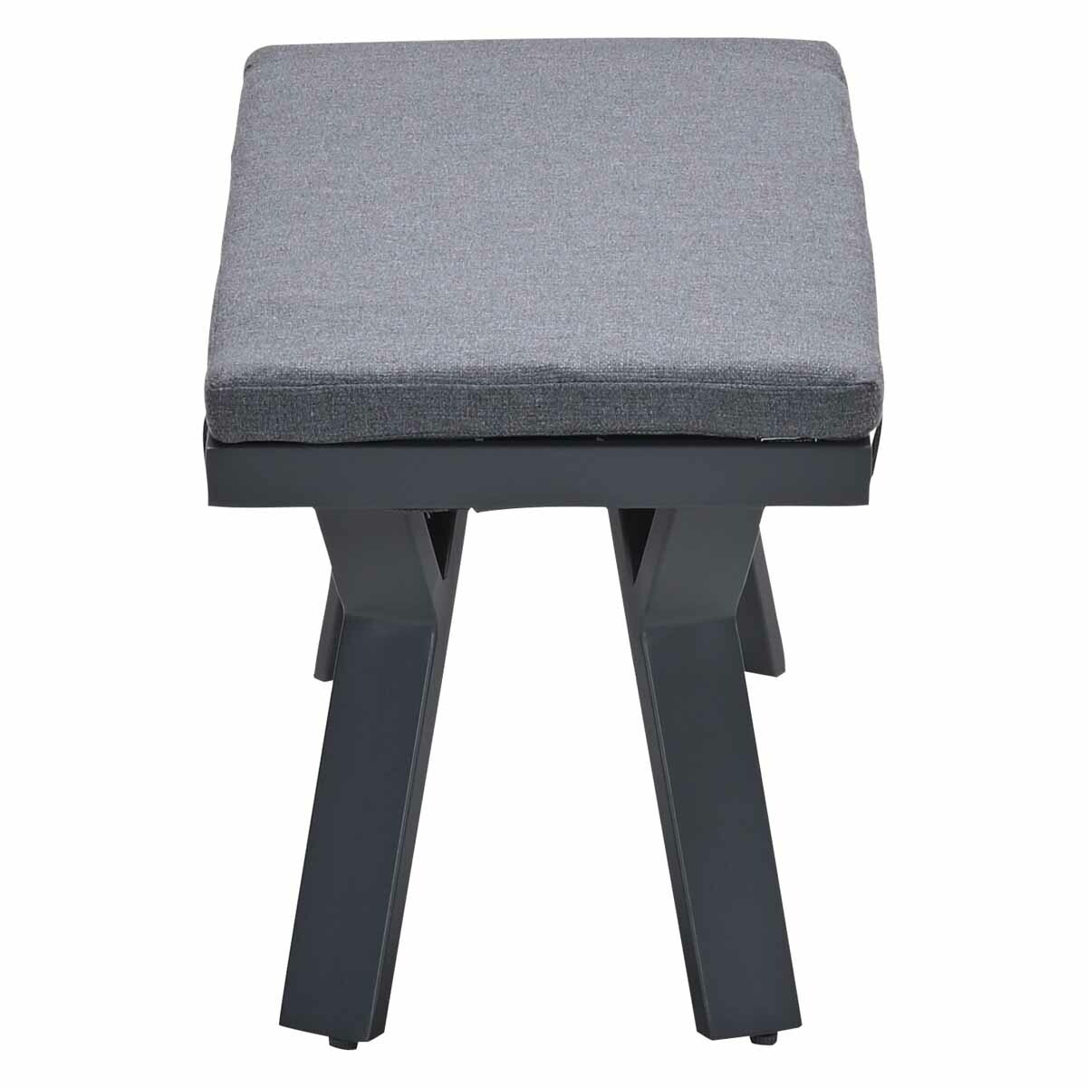 A gray bench with a gray cushion. The frame is gray, the legs are crossed.
